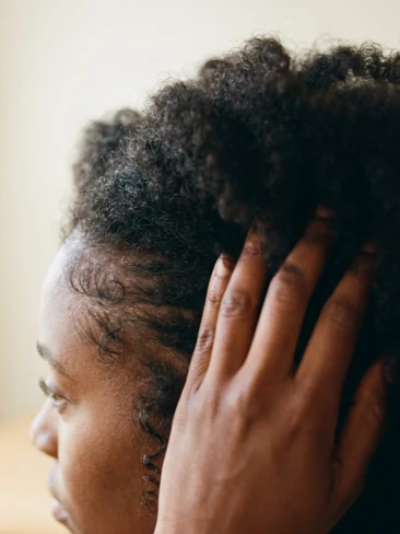 Mulher tocando o cabelo crespo na raiz