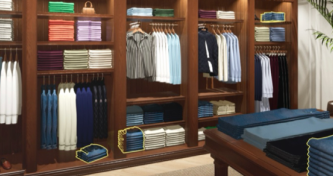 TechTalks Episode 03, Dtail: a menswear retail interior with shelves of folded shirts and hanging garments in dark wood display units.