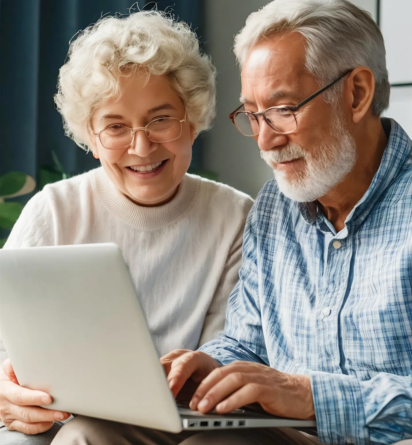 Smiling elderly couple with glasses using a laptop together indoors.