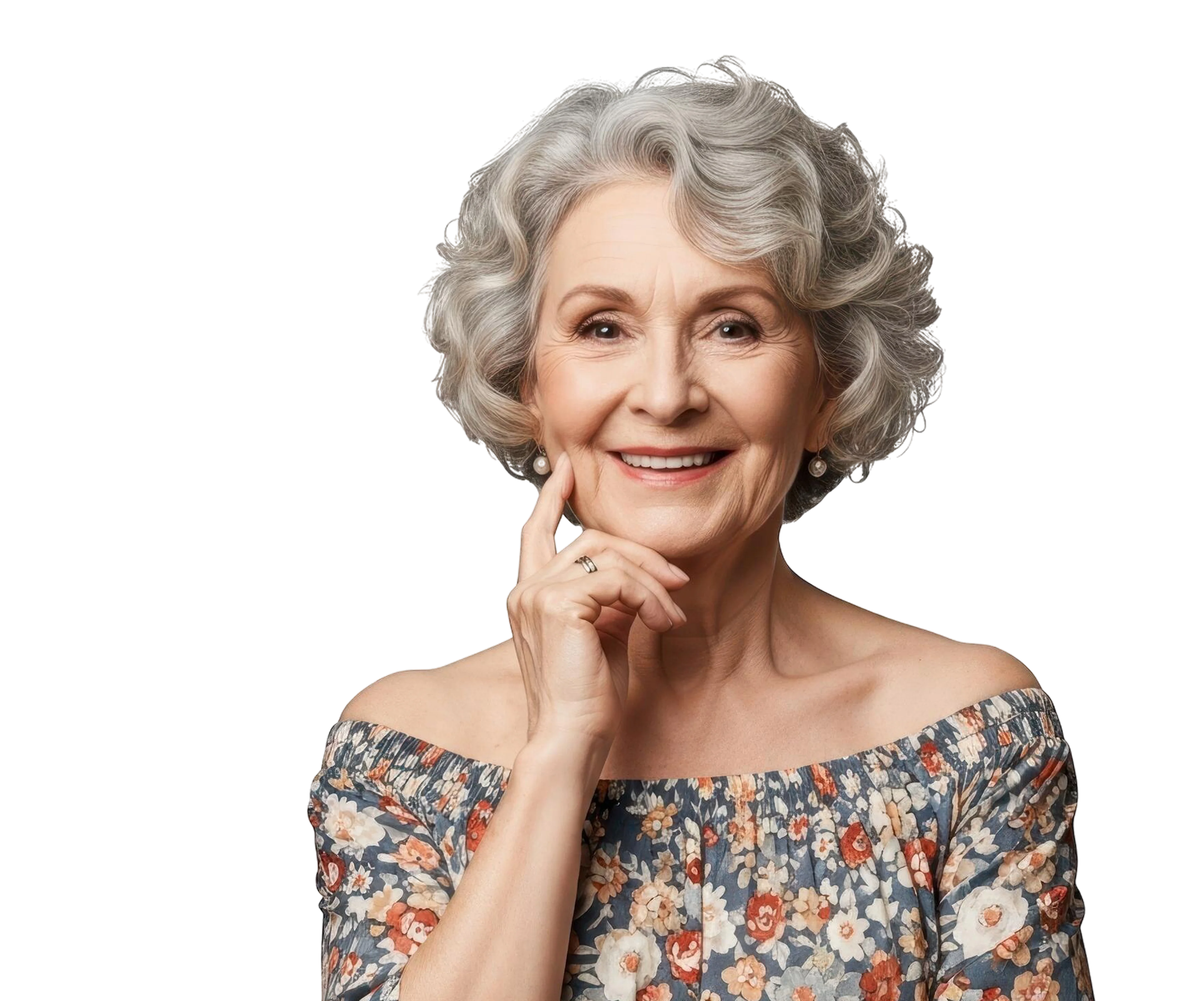 Smiling elderly woman with gray curly hair wearing floral off-shoulder top, resting her chin on her hand.