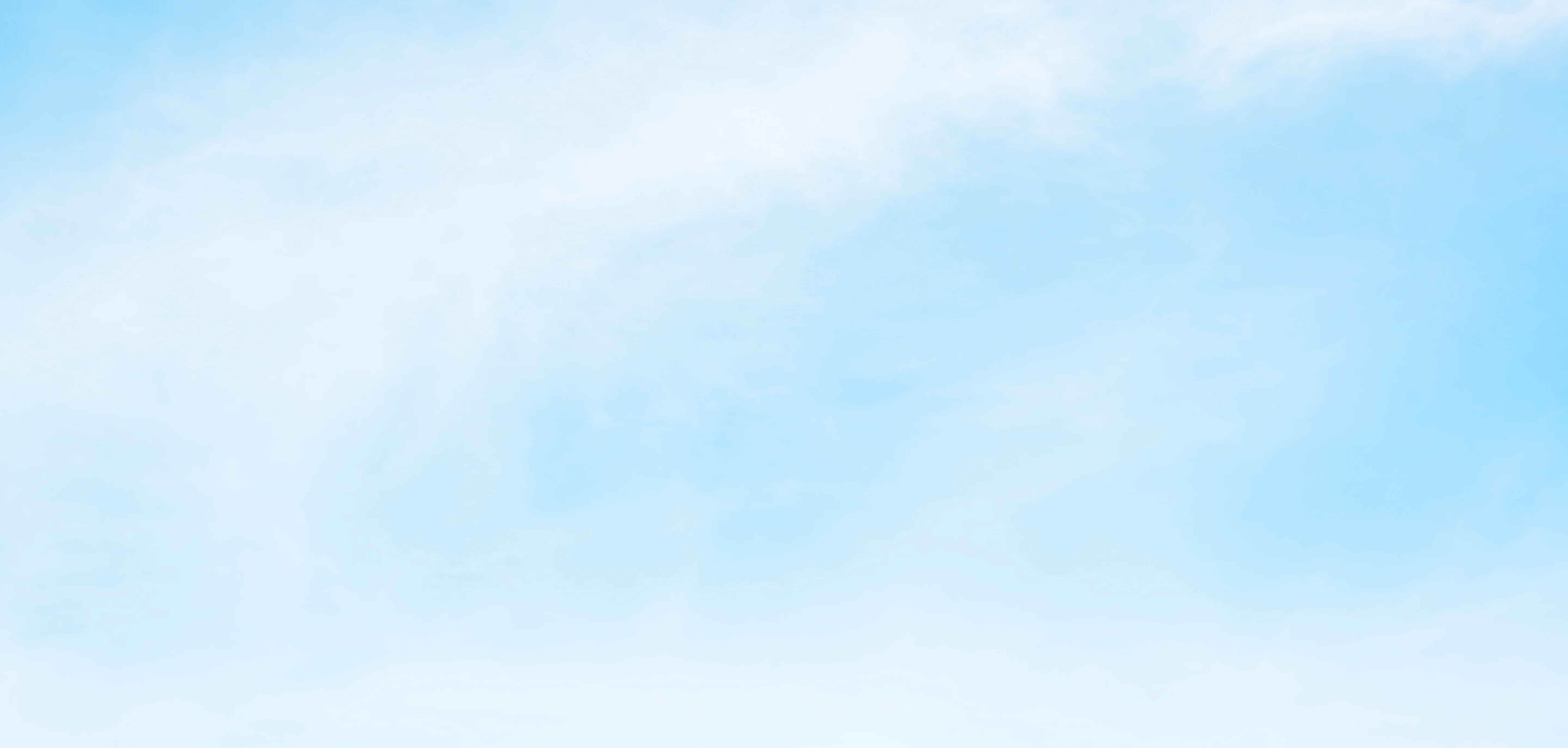 Bright blue sky with soft, wispy white clouds.