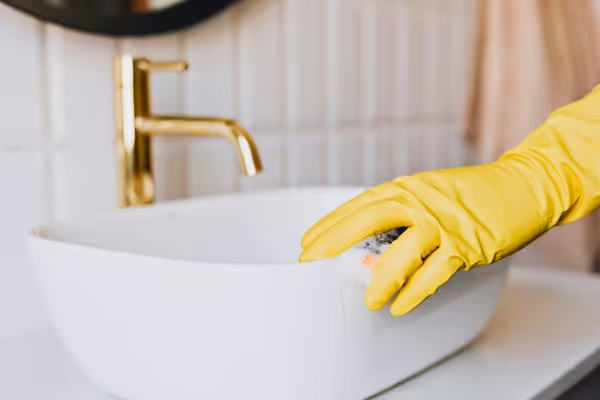 cleaning a sink with gloves on