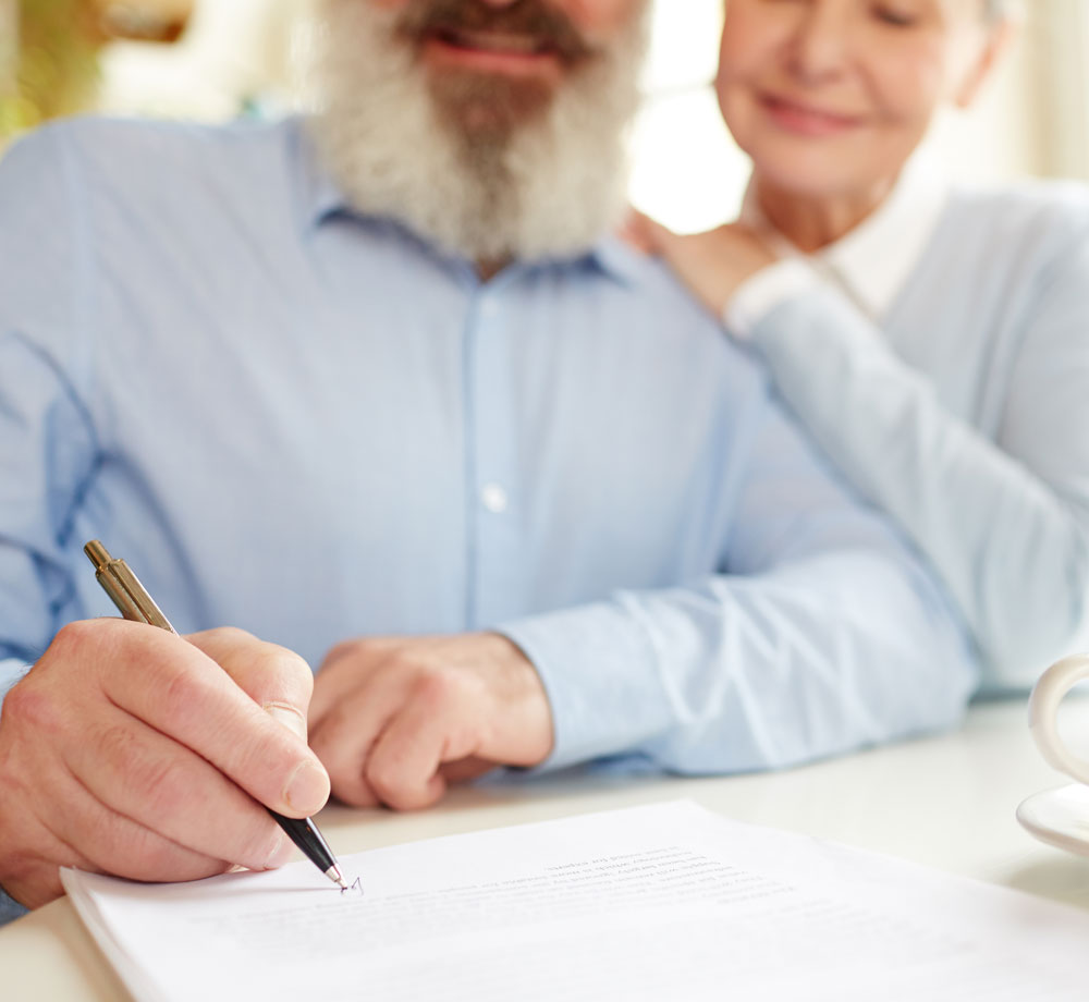 A couple signing their estate planning documents