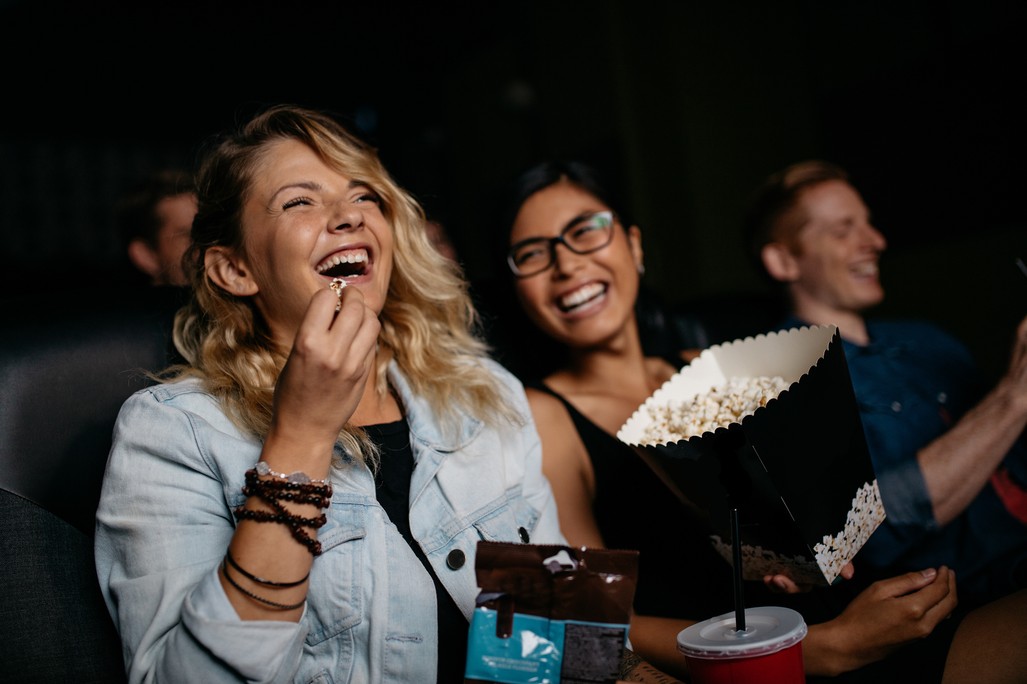 woman at movies with popcorn stock image