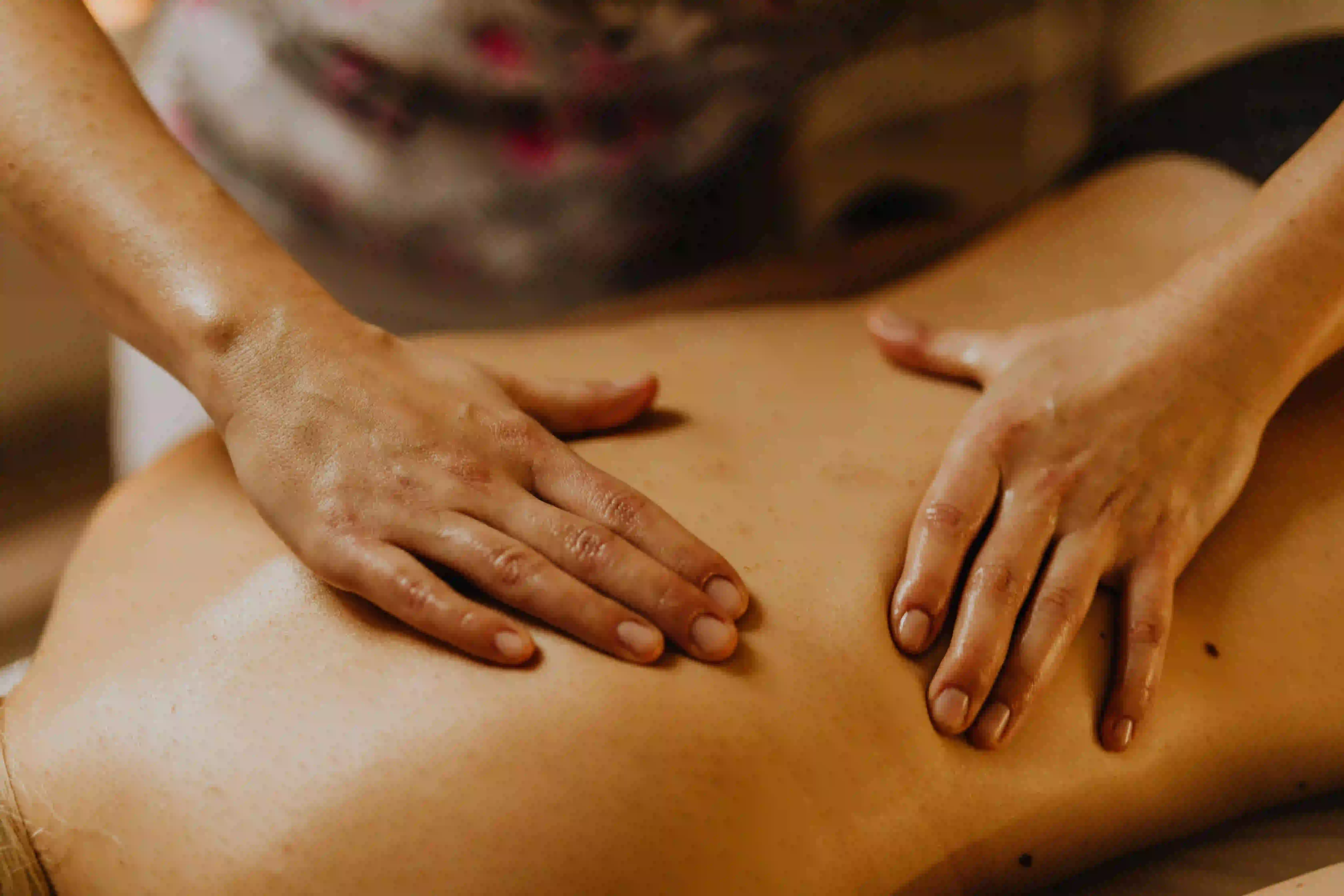 twee handen op een rug tijdens massage
