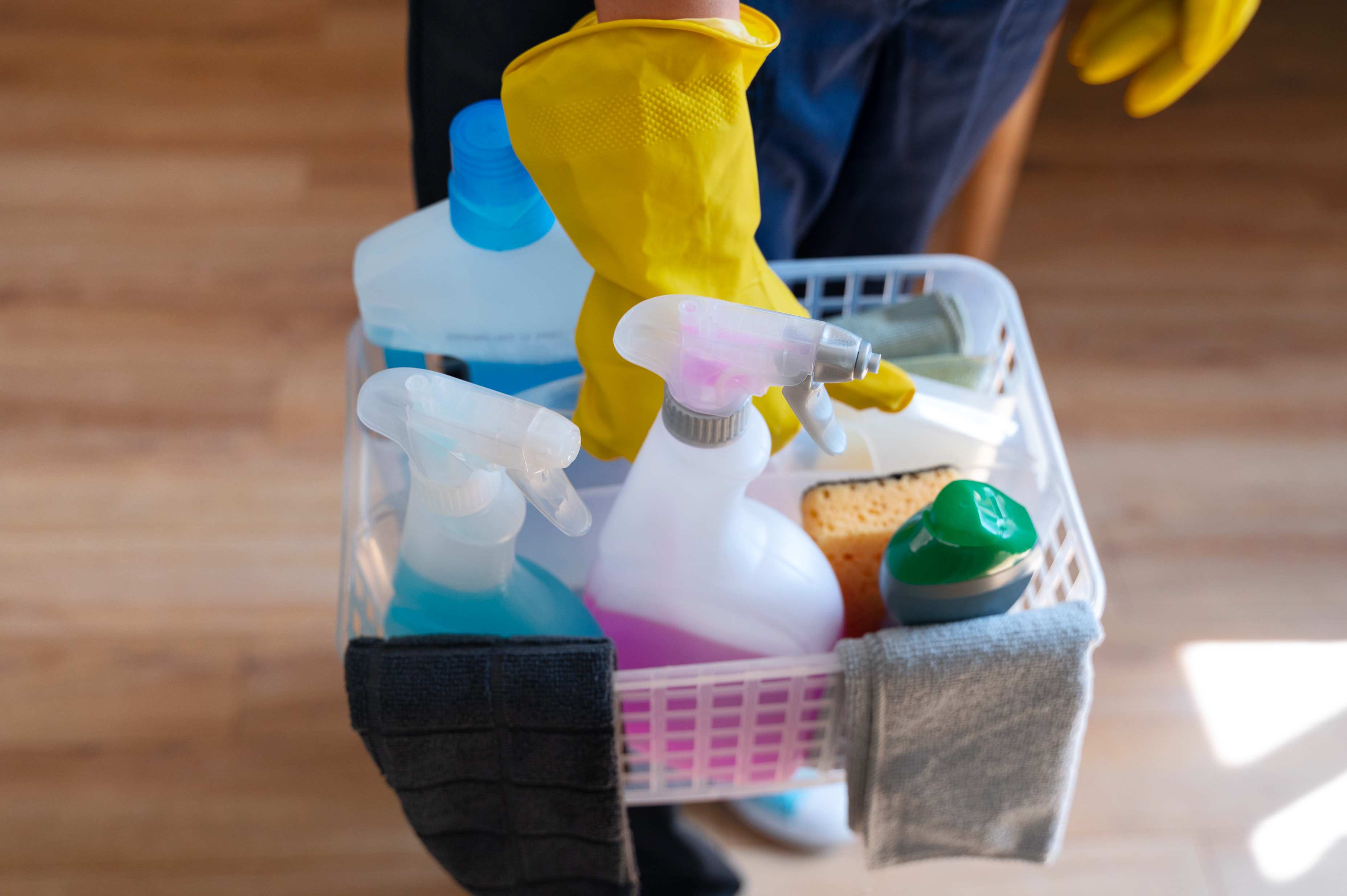 high angle of woman holding cleaning supplies inside a home