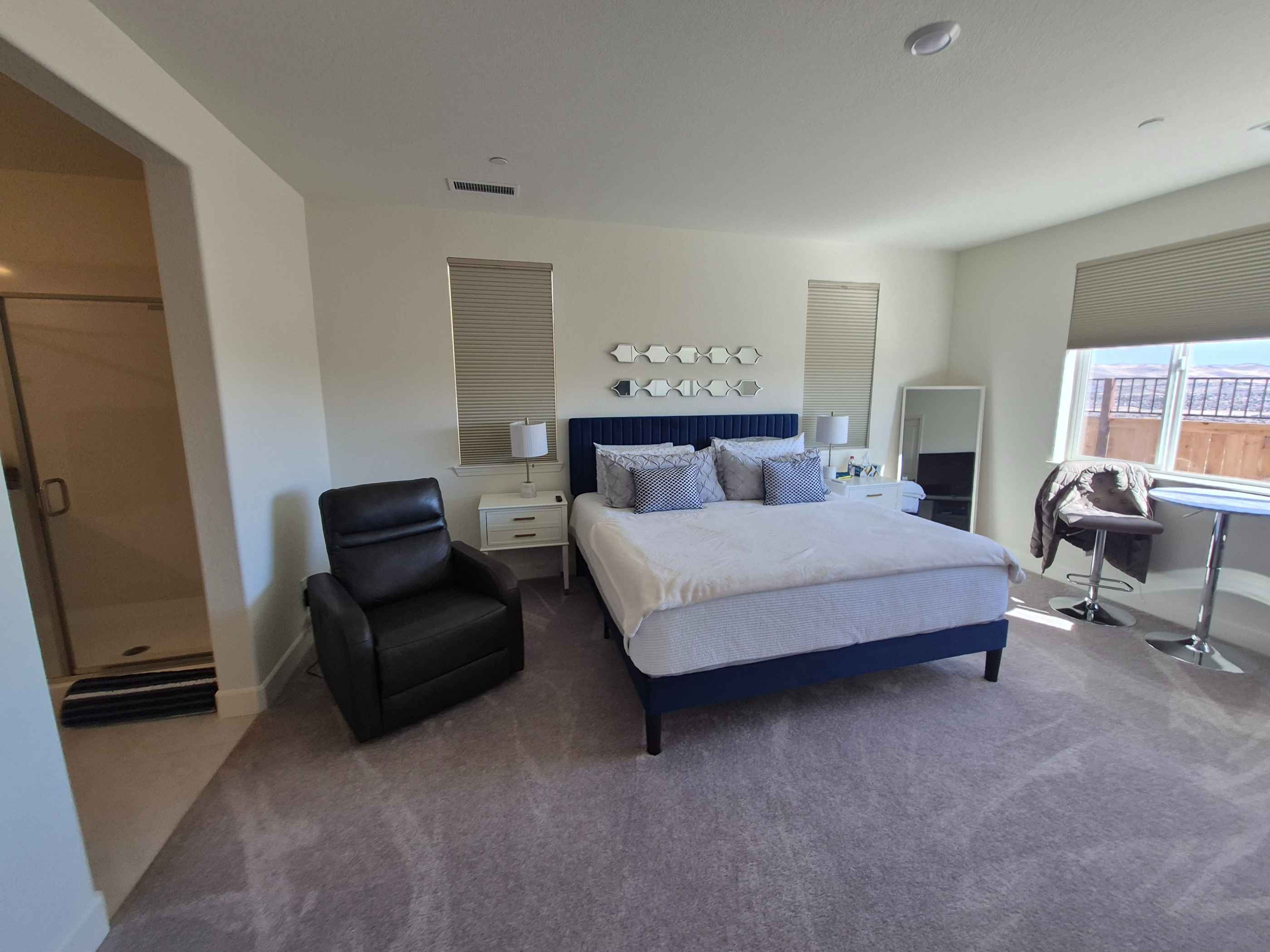 wide photo of a clean and and clearly vacuumed bedroom