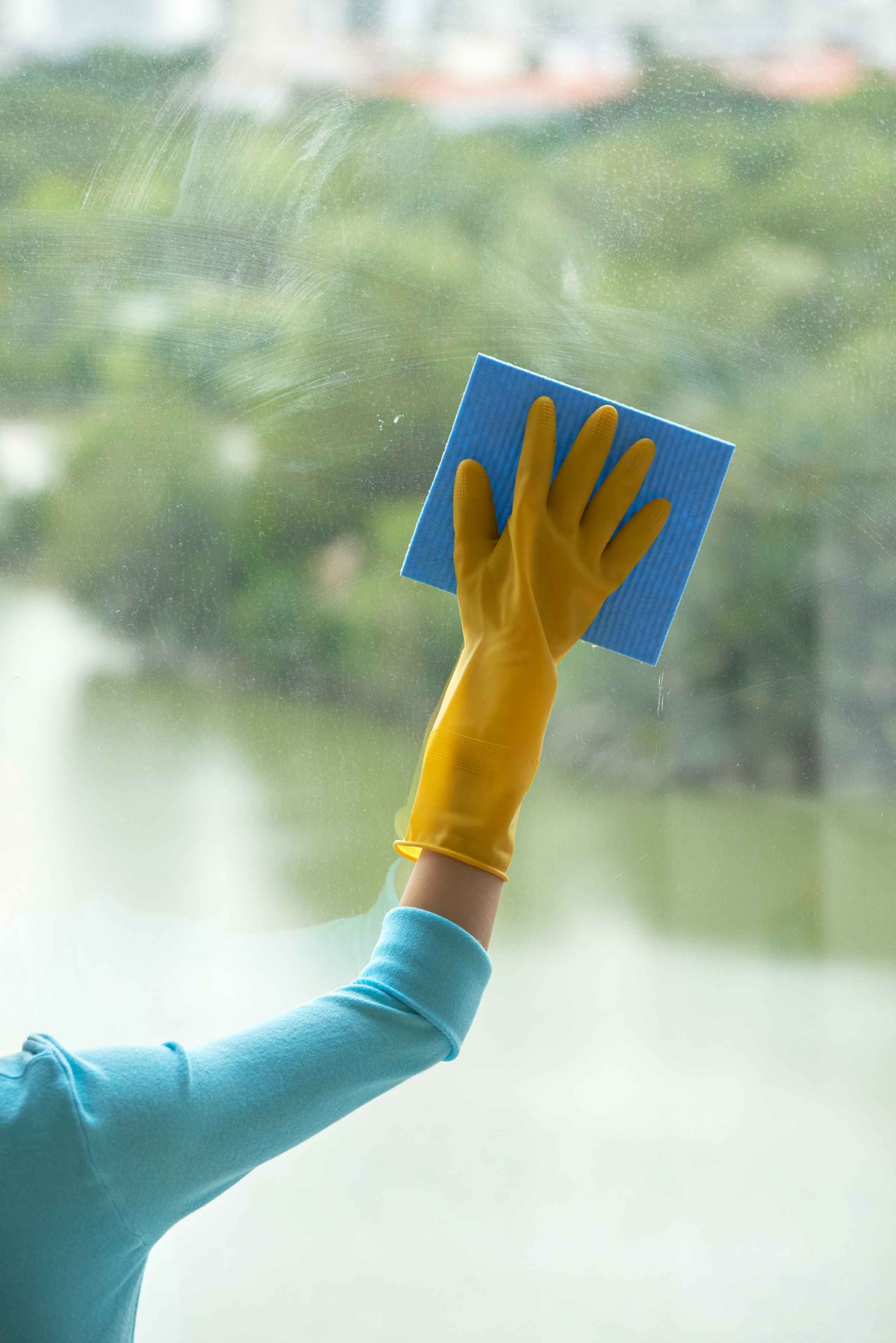 cropped hand unrecognizable woman cleaning panoramic window