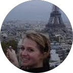 Woman smiling with the Eiffel Tower in the background.