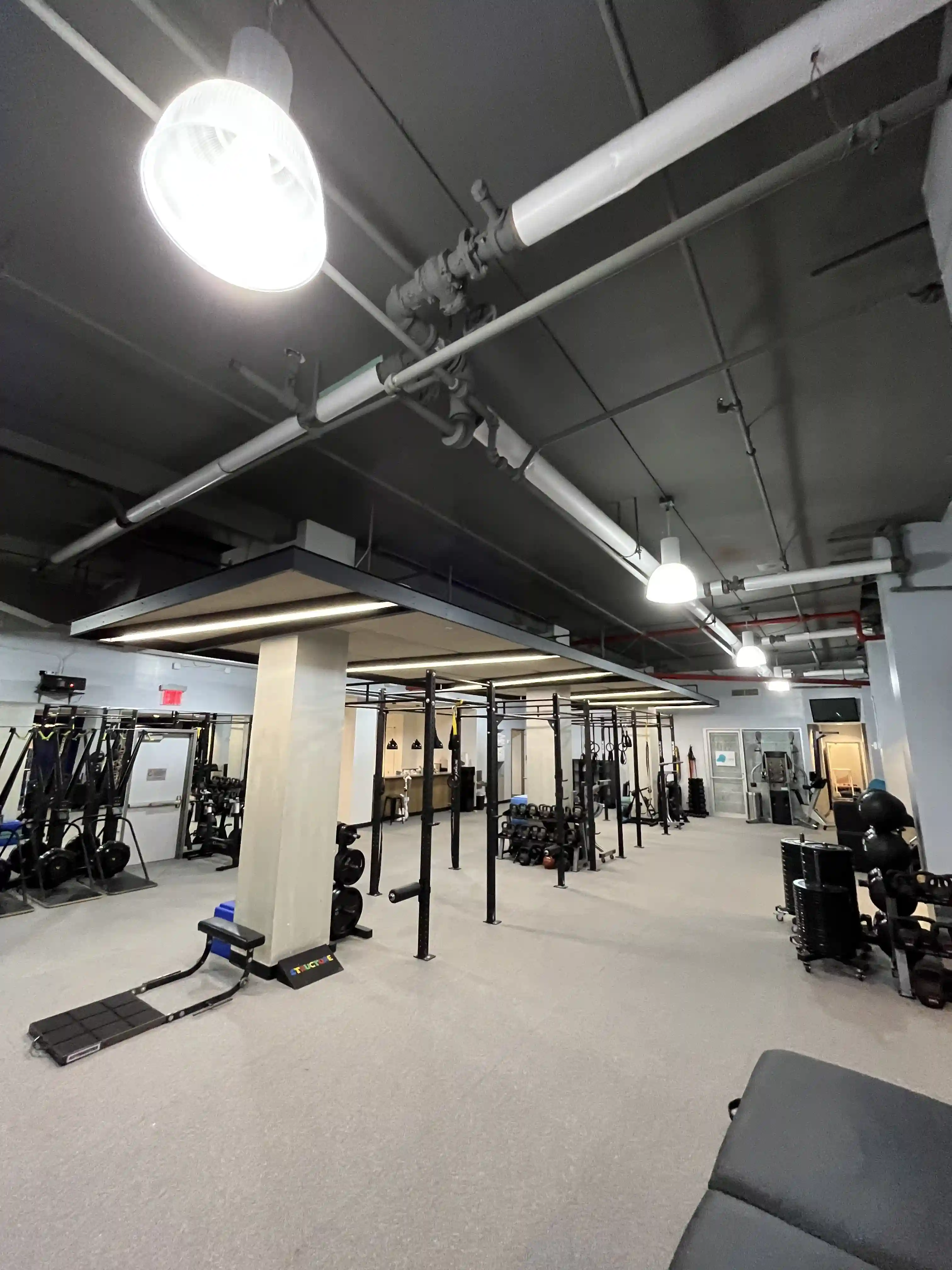 Equipment zone inside Structure PF gym with workout machines and mirrors.