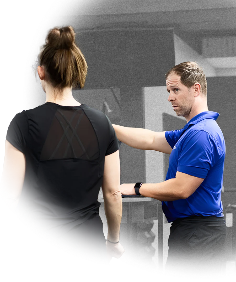 Kevin Dineen coaching a female client during strength training at Structure PF.