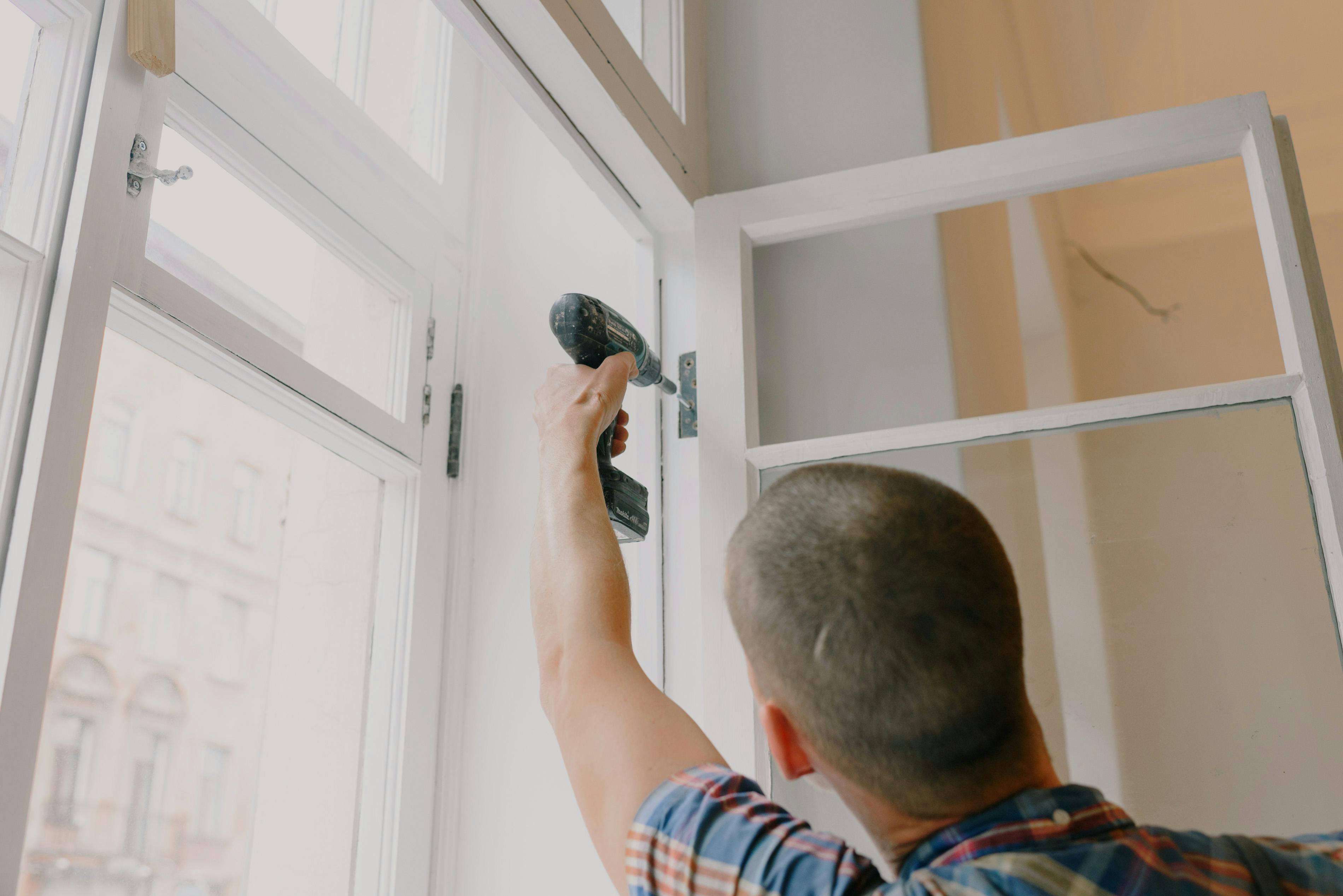 A man fitting a sash window