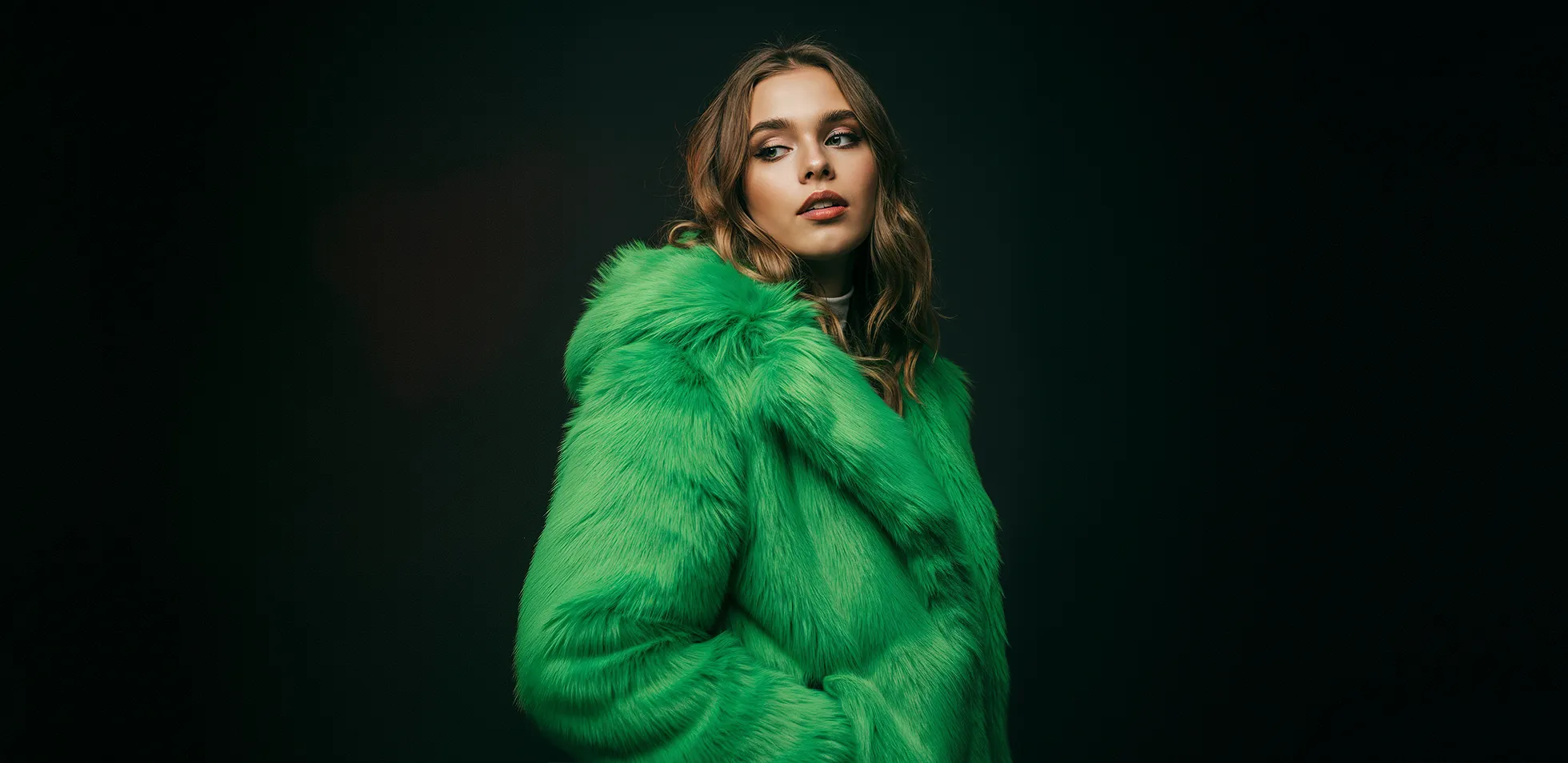 woman wearing green jacket with dark background