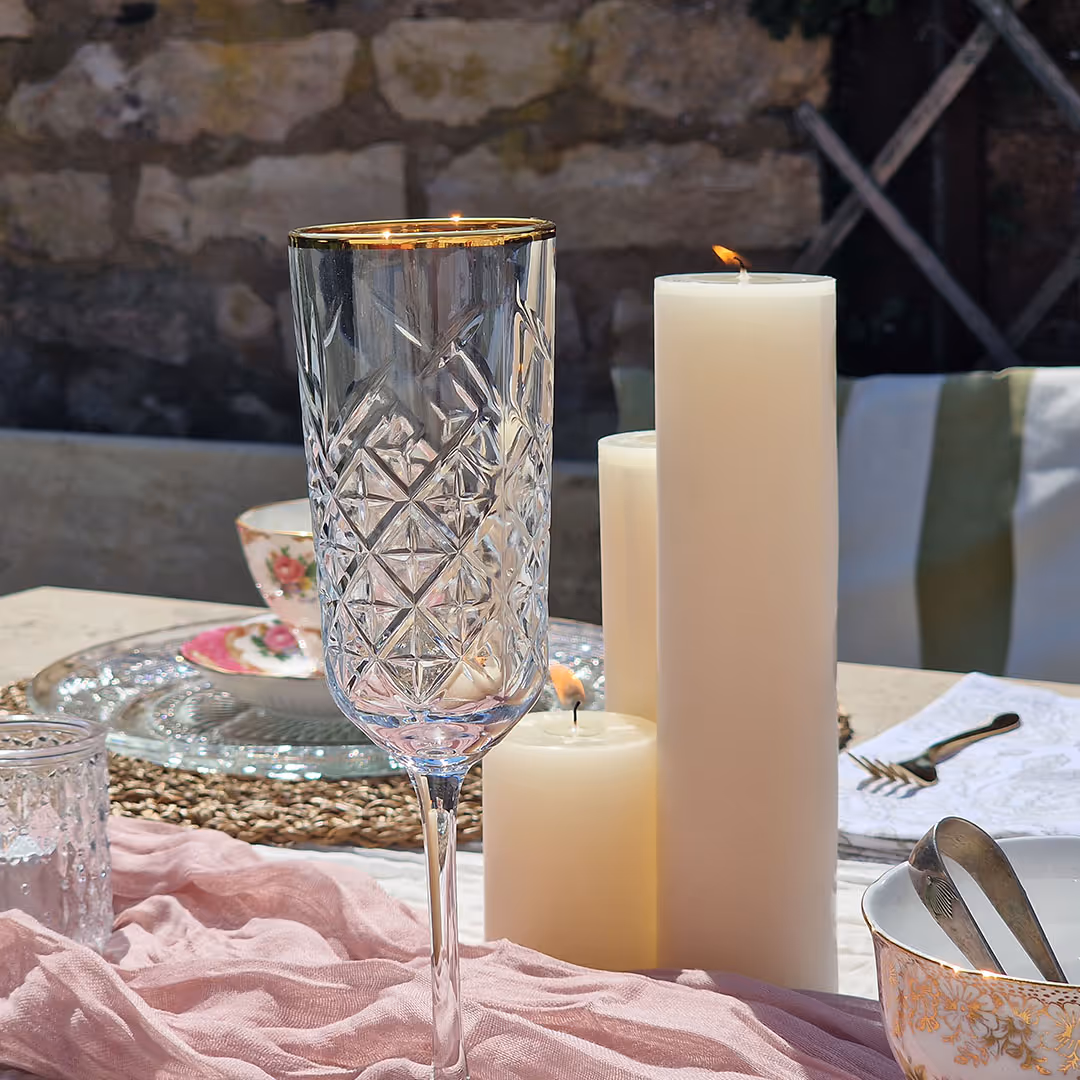 Elegant table setting with crystal glass, candles, and pink fabric