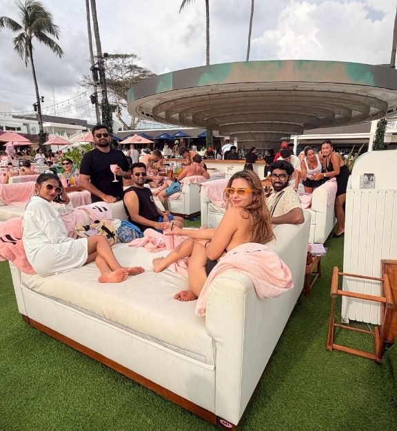 Group of friends relaxing on white outdoor bed at Finns with Triptease