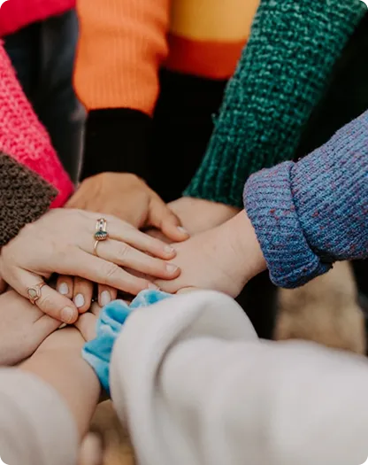 A group of girls hands placed on each other.