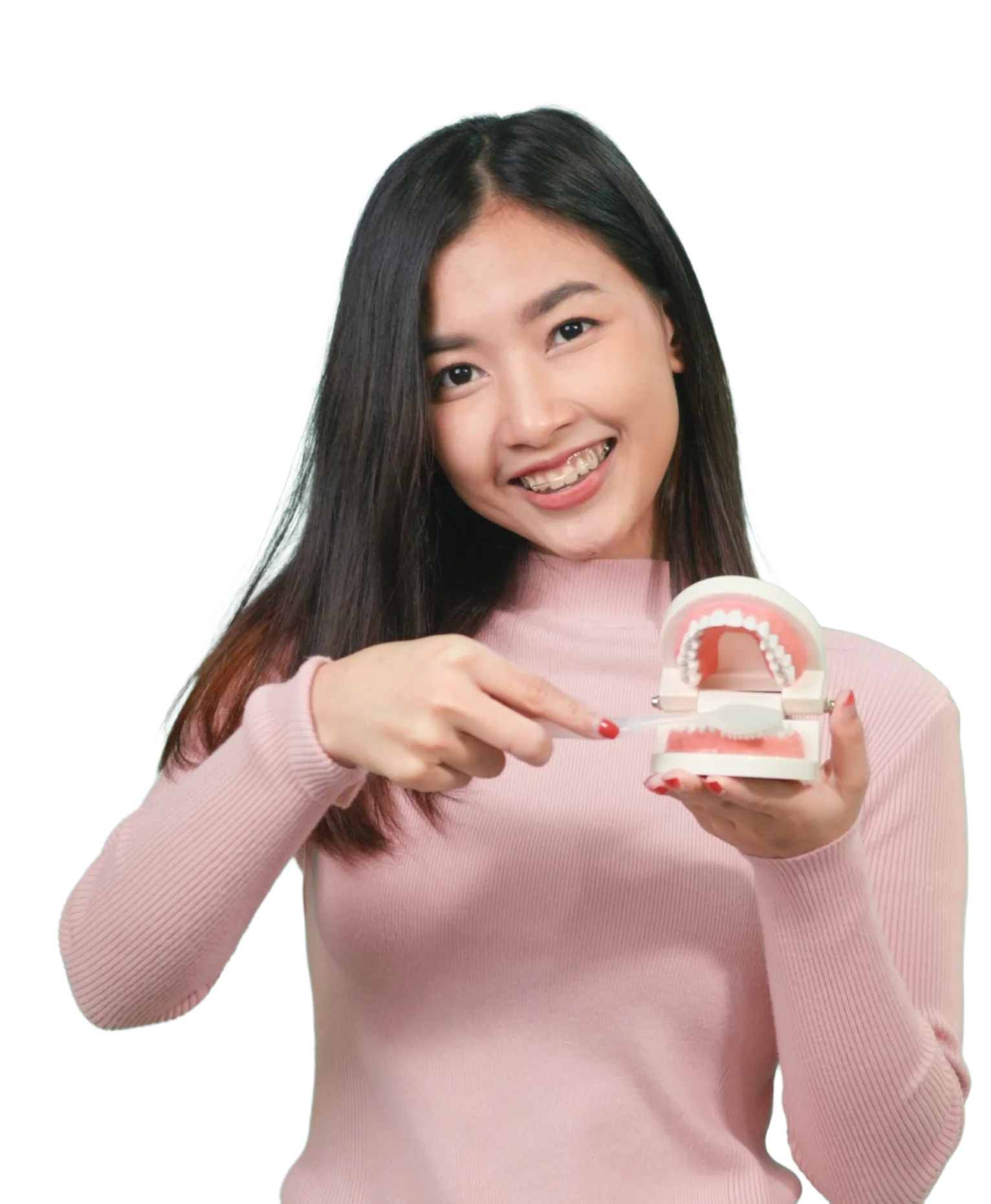 Young woman with braces smiling and demonstrating tooth brushing on a dental model with a toothbrush at Omnia Dental Care in Chino Hills, CA