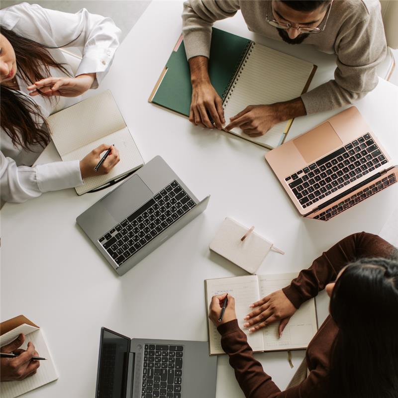 Besprechung mit vier Personen vor Laptop