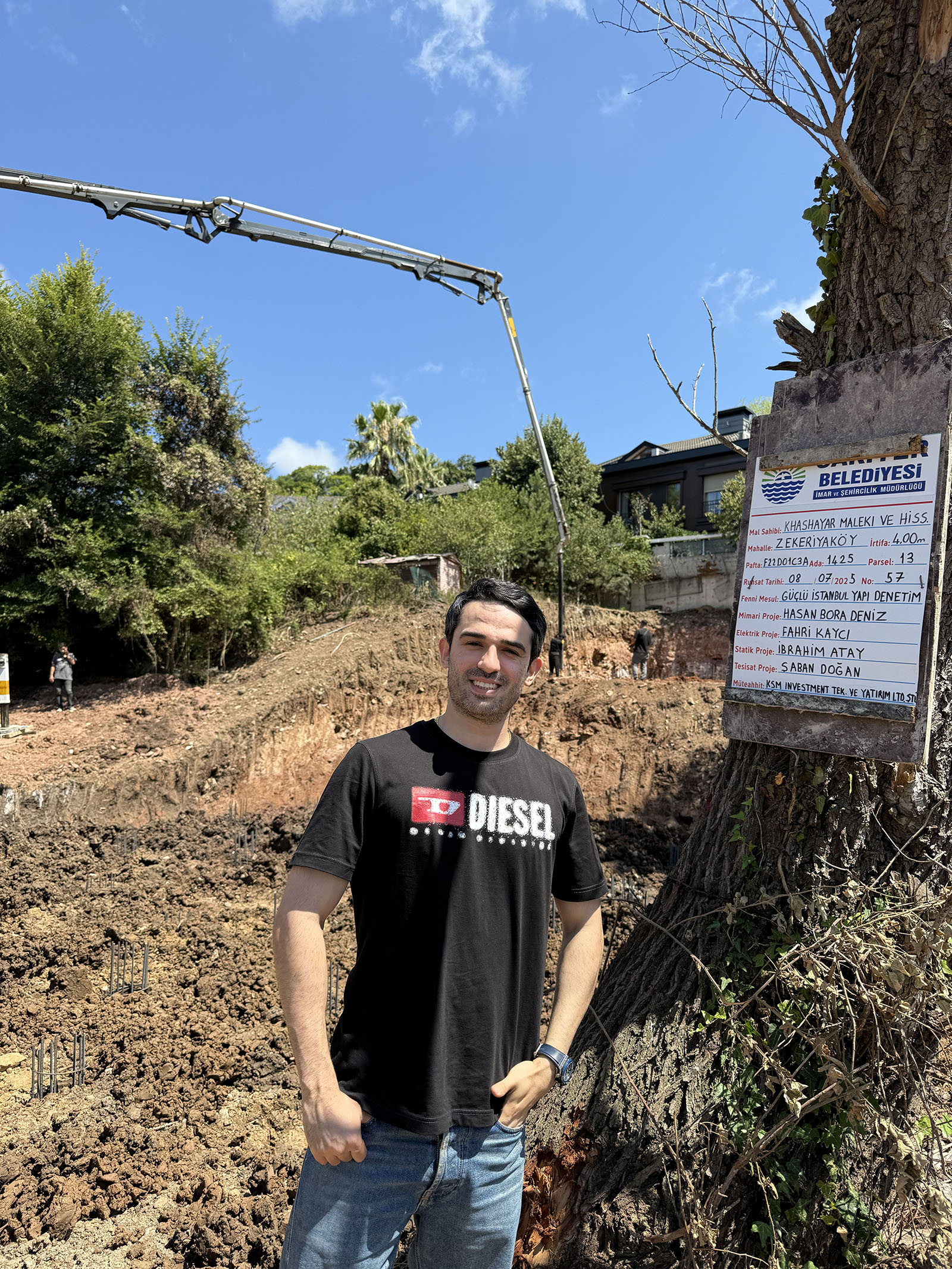 Contemporary two-story house with dark exterior panels and wooden accents, featuring a sloped roof, private pool, sun loungers, and outdoor seating area with barbecue in lush green surroundings.