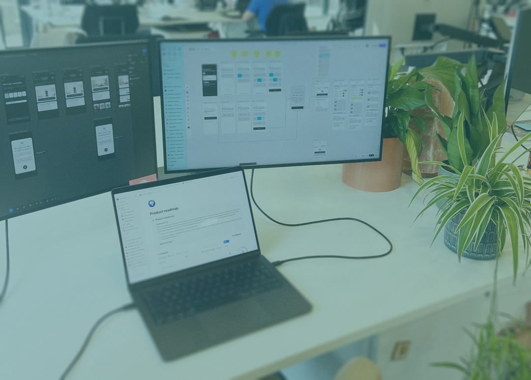 An office desk with screens and laptop