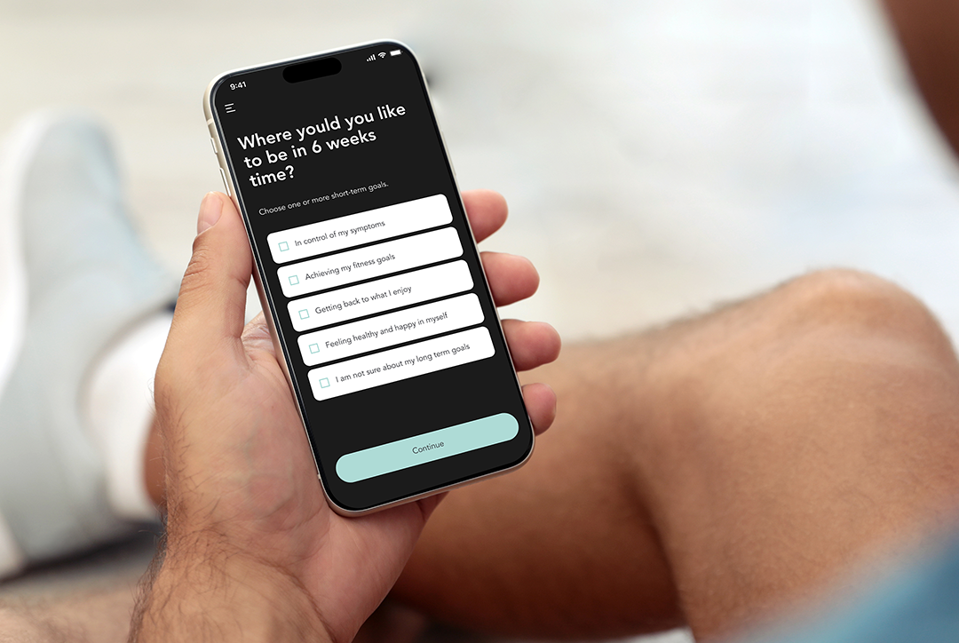 A man looking at his phone that displays the Flok Health app.