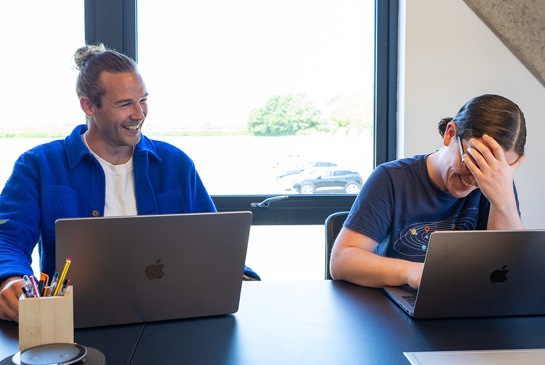 Employees from Flok Health sharing a laugh during a meeting