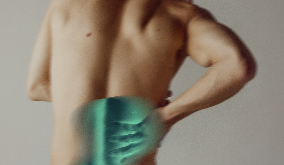 A man holding his lower back in pain.