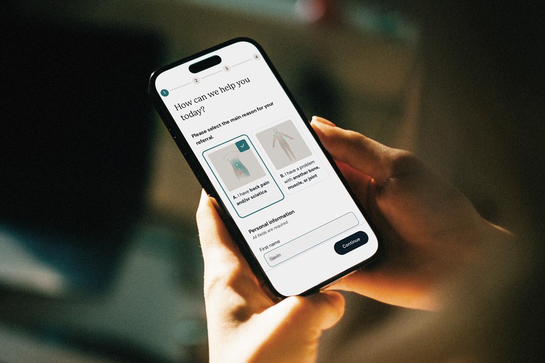 Person holding a smartphone displaying the Flok Health registration form for lower back pain.