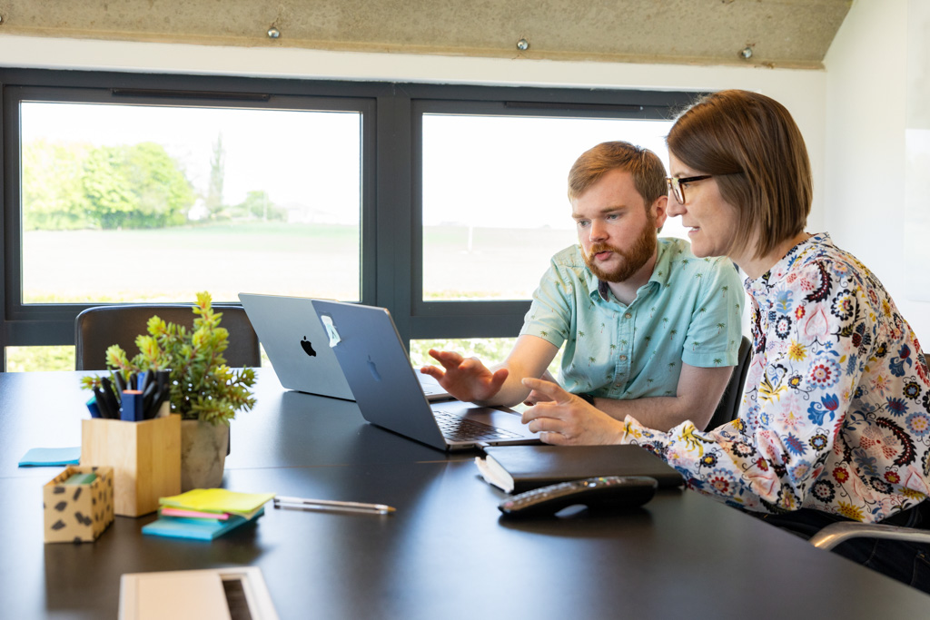 Man and woman sitting at a conference table having a meeting.