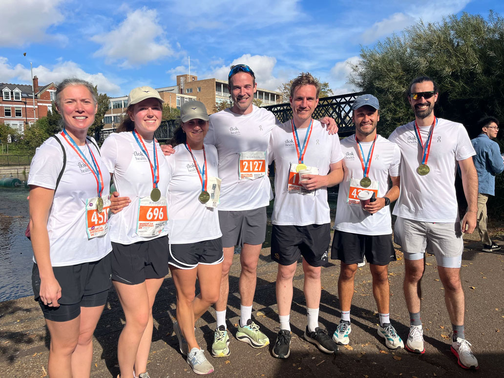 A group of employees from Flok Health in running clothes standing together