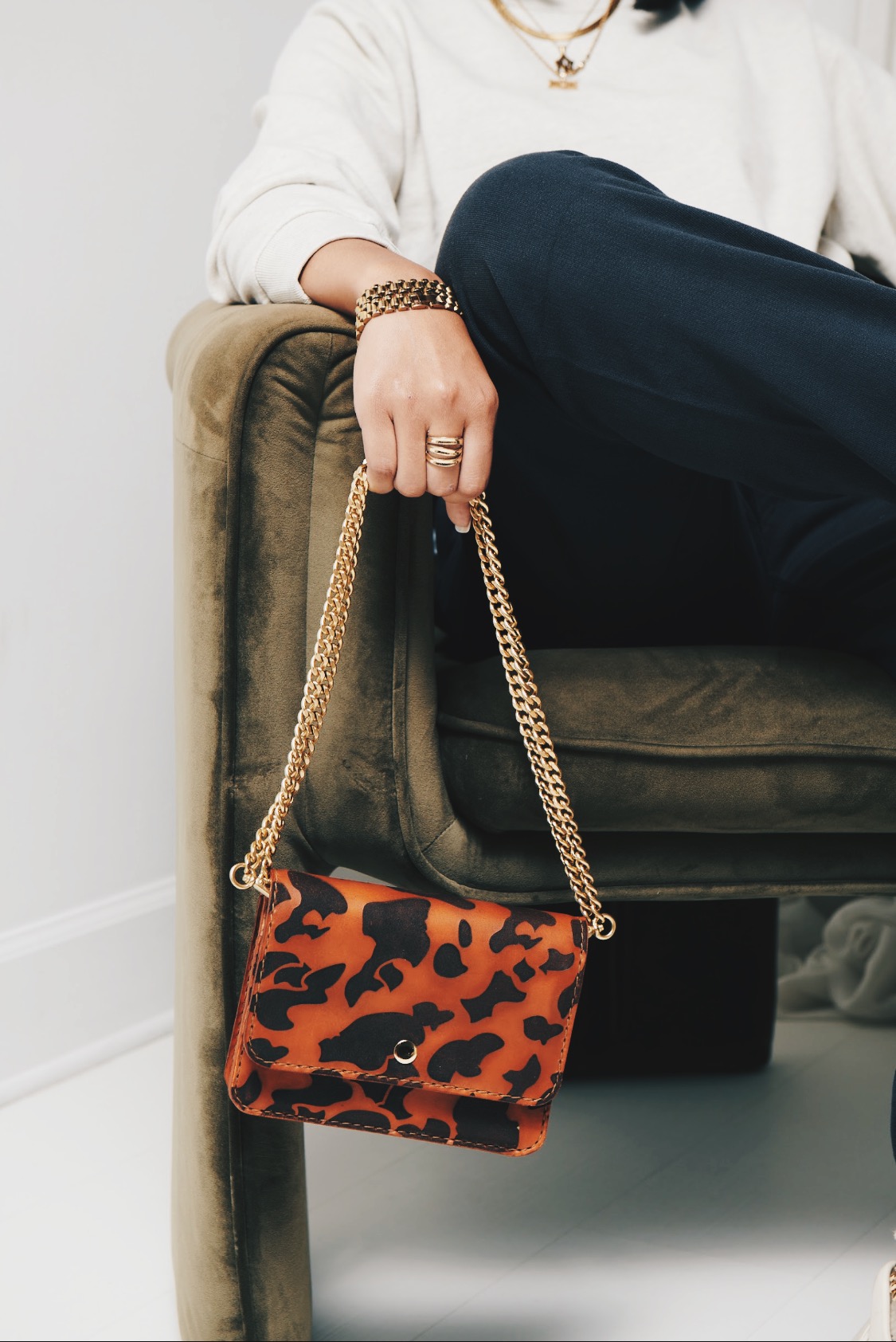 A photo of a woman wearing a SUNDRIES camo wallet on chain. 