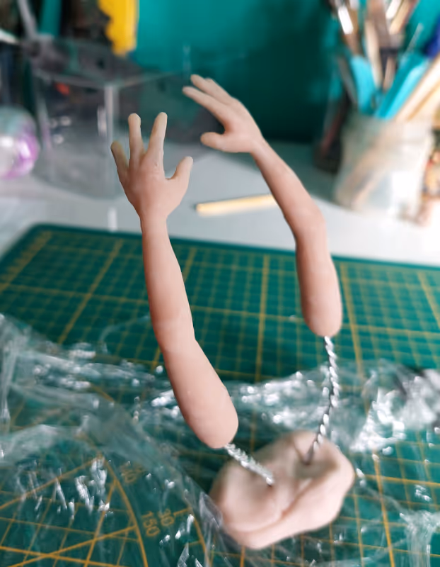 Armpjes voor een stop-motionpop die te drogen staan in een stukje klei