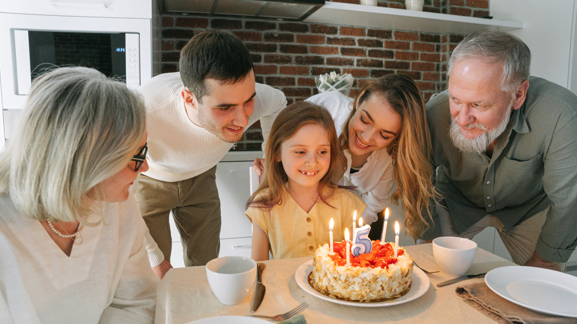 A family gathered at the kitchen table celebrating a little girls birthday