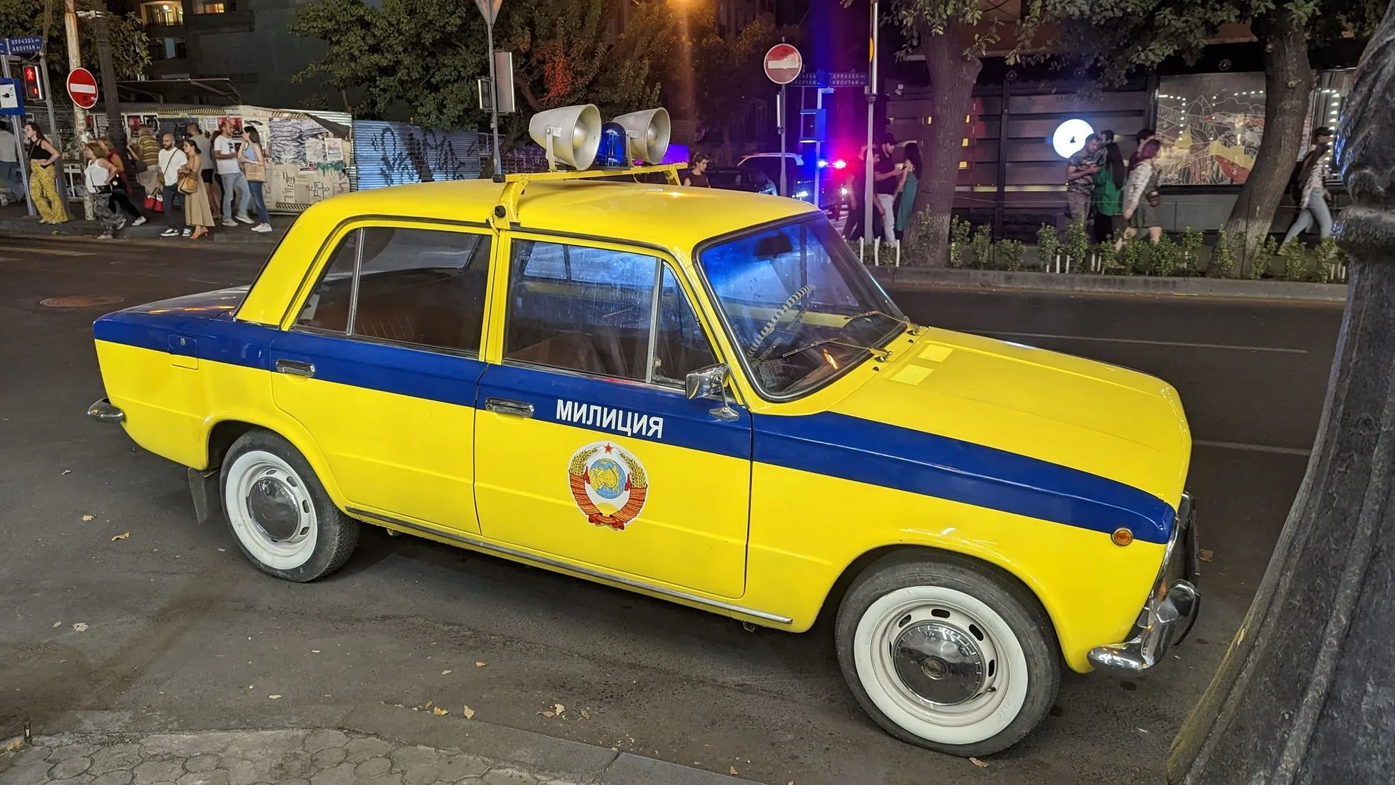 Vintage Soviet-era police car in Yerevan, Armenia, painted in yellow and blue with "Militsiya" written on the side.
