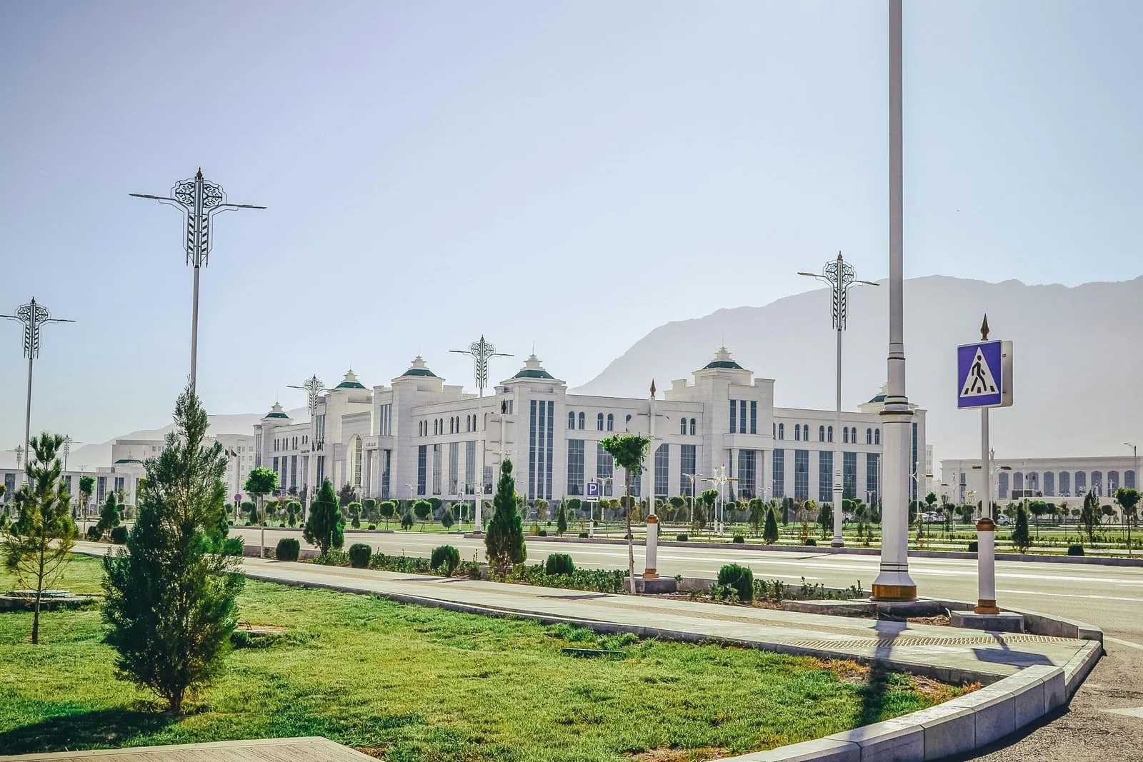 A grand avenue in Ashgabat, Turkmenistan, lined with white marble buildings and modern architecture.