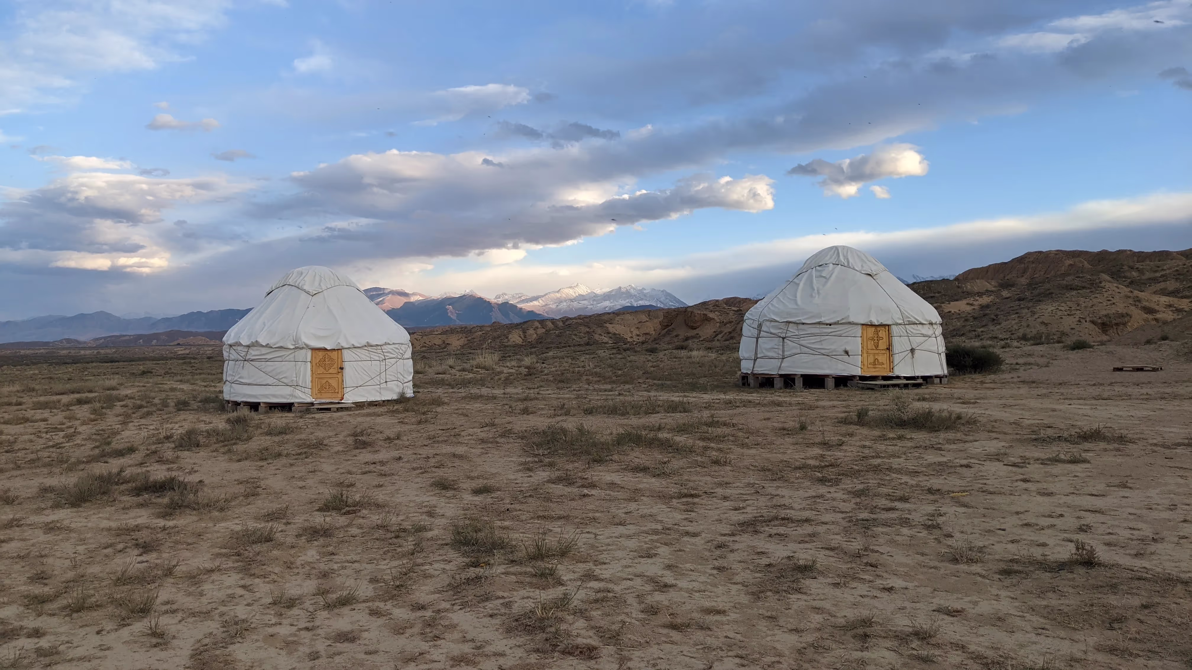 Traditional yurts set against a scenic mountain backdrop, showcasing Kyrgyzstan’s nomadic heritage.