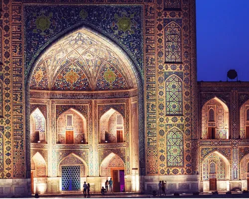 The intricate tilework of Samarkand’s historic mosque, illuminated in golden lights at night.