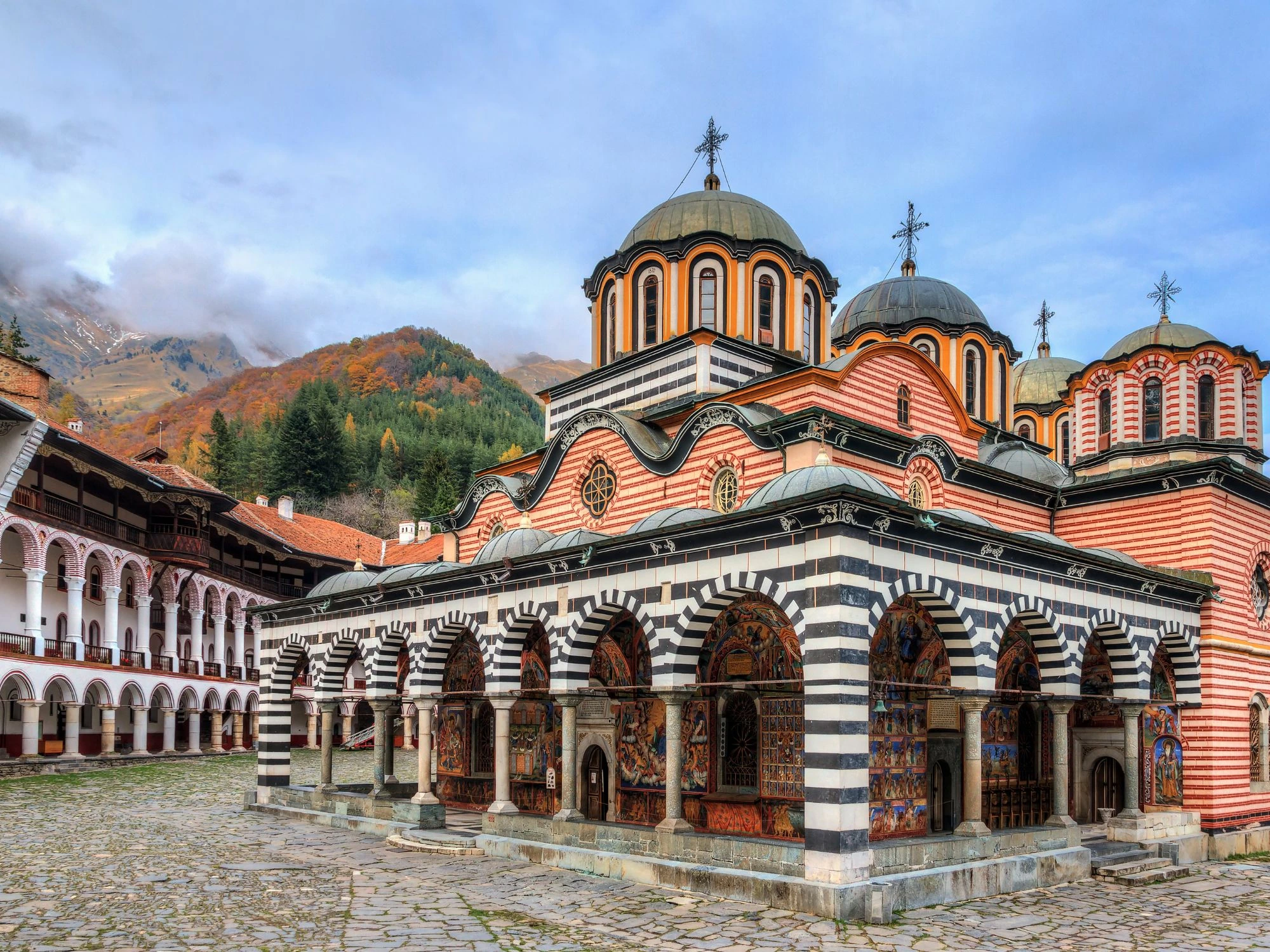 The stunning Rila Monastery in Bulgaria, a UNESCO site with ornate frescoes and domed architecture in autumn.