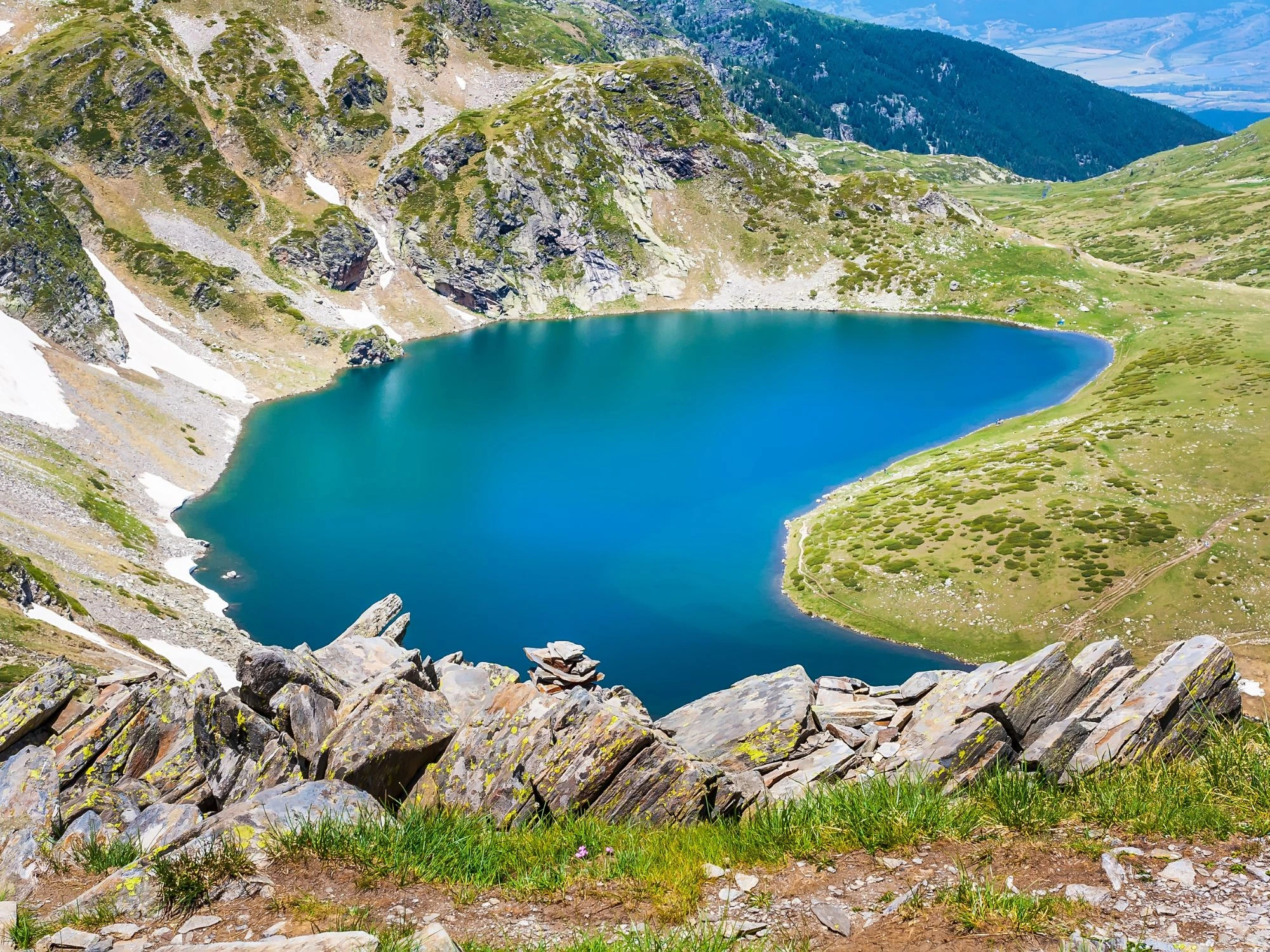Aerial view of the strikingly blue Seven Rila Lakes, nestled in Bulgaria’s Rila Mountains, surrounded by rugged slopes.