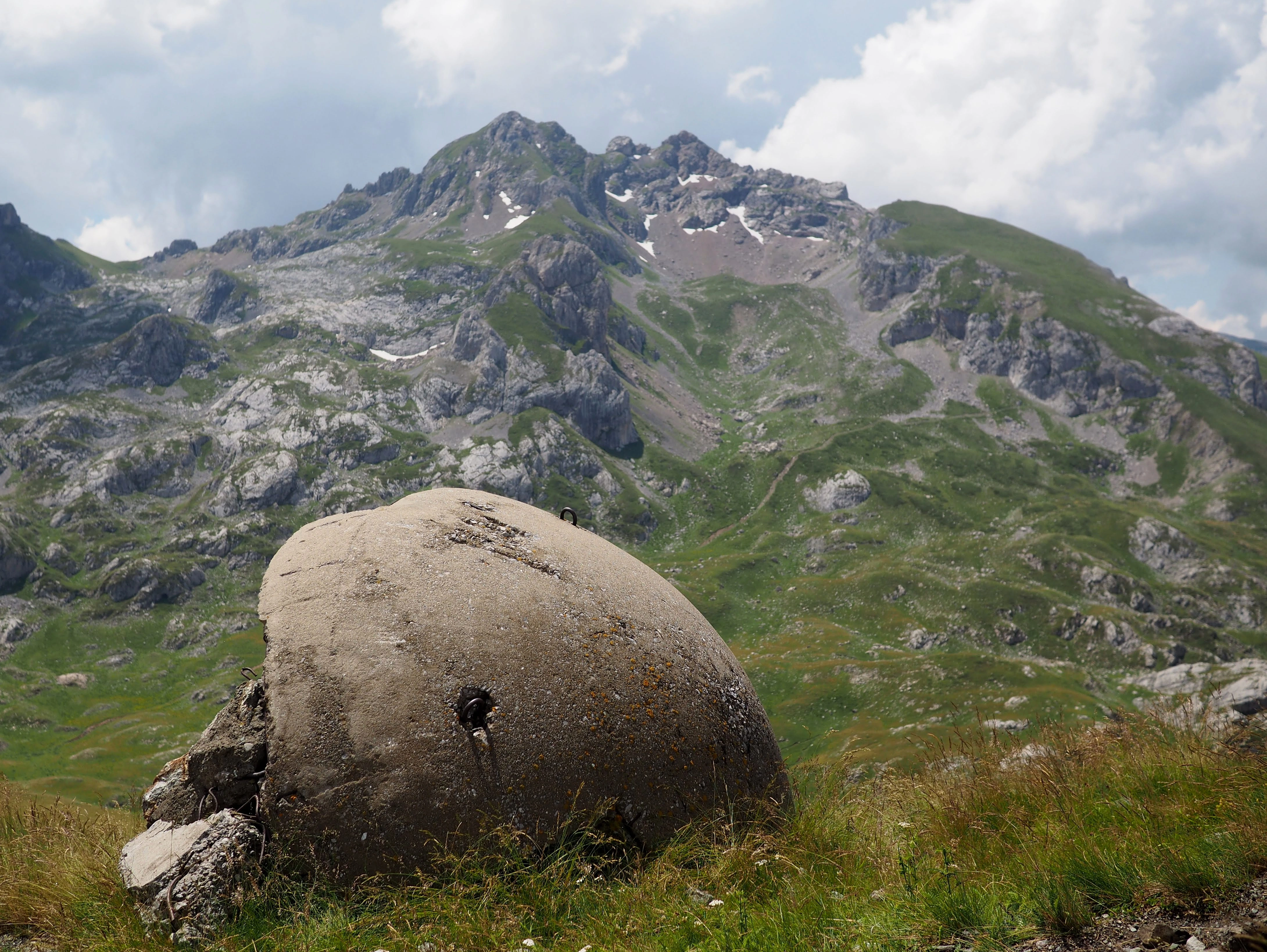 Bunker in High Scardus – A weathered concrete bunker sits in alpine meadows, rugged mountains rising in the background.
