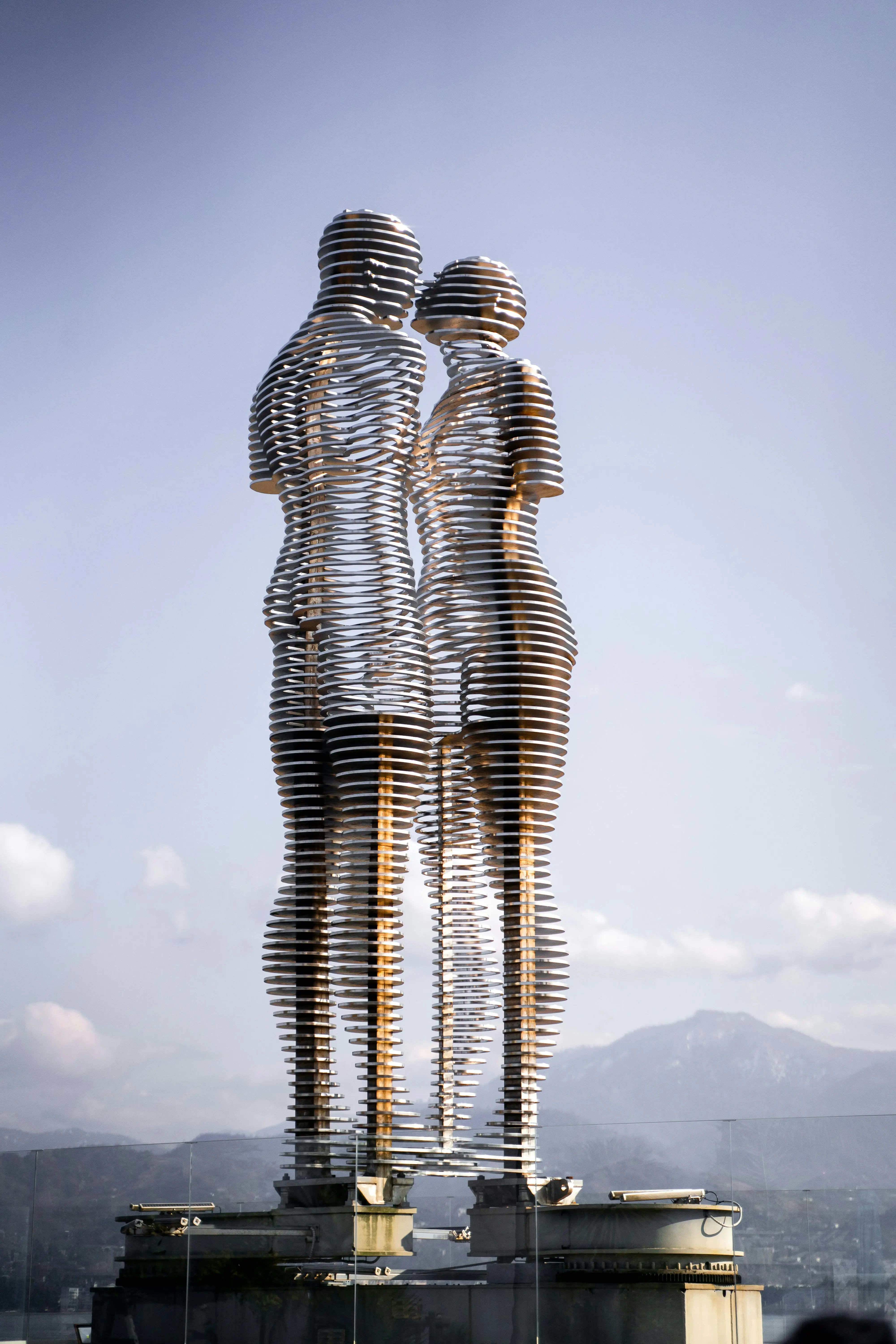 The "Ali and Nino" moving statue in Batumi, Georgia, depicting two lovers made of metal slats against a mountain backdrop.
