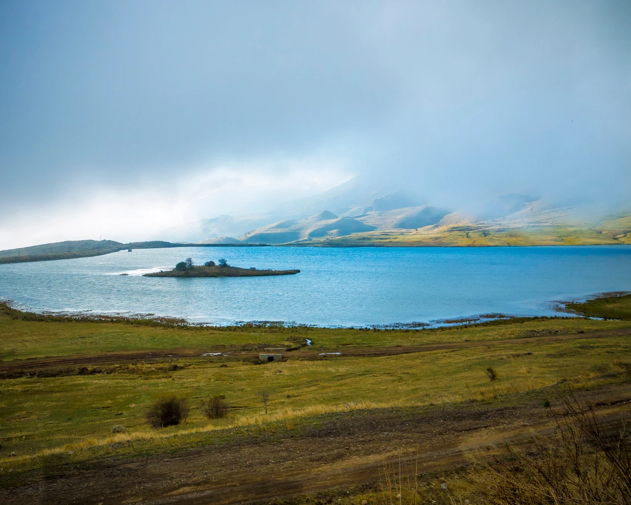 Serene Lake in Nakhchivan, Azerbaijan - Misty lake surrounded by rolling hills, creating a peaceful landscape.