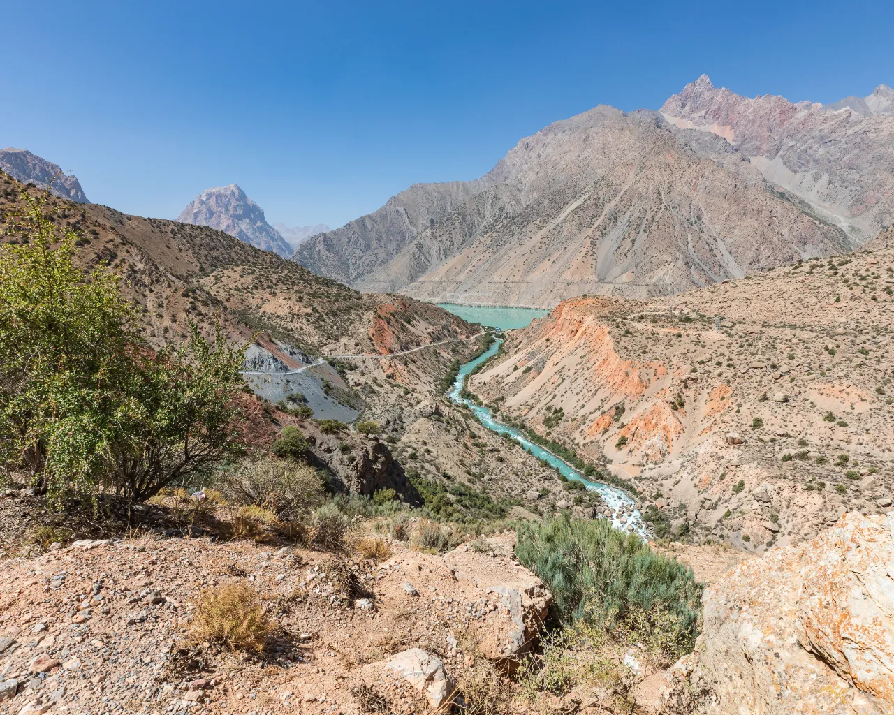 Yaghnob River, Tajikistan: The river snakes through an arid valley, meeting the blue waters of Iskanderkul Lake.