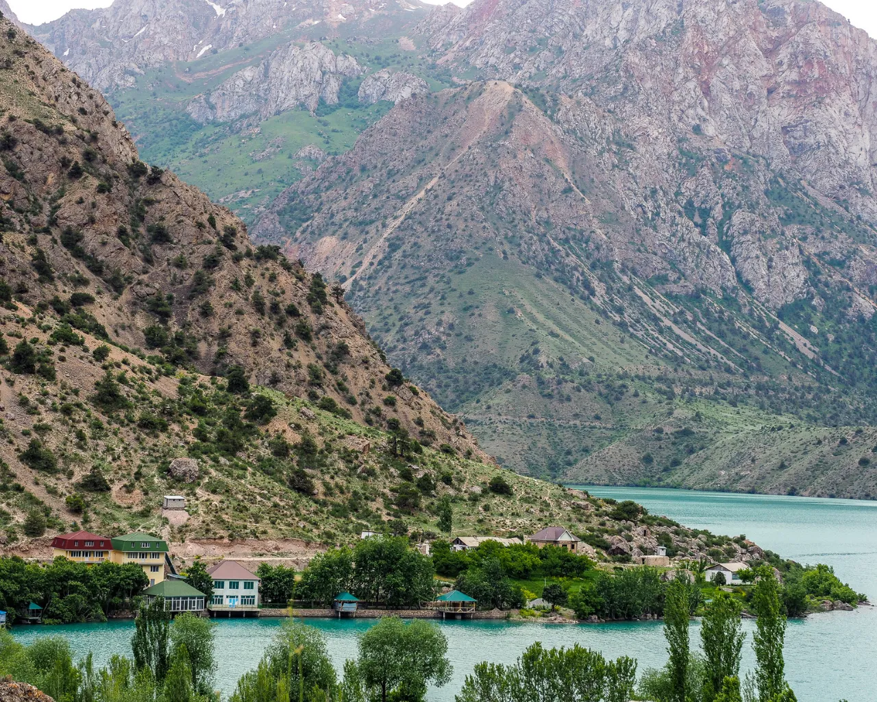 Iskanderkul Lake, Tajikistan: A turquoise glacial lake sits among rugged mountains in the Fann Range of Tajikistan.