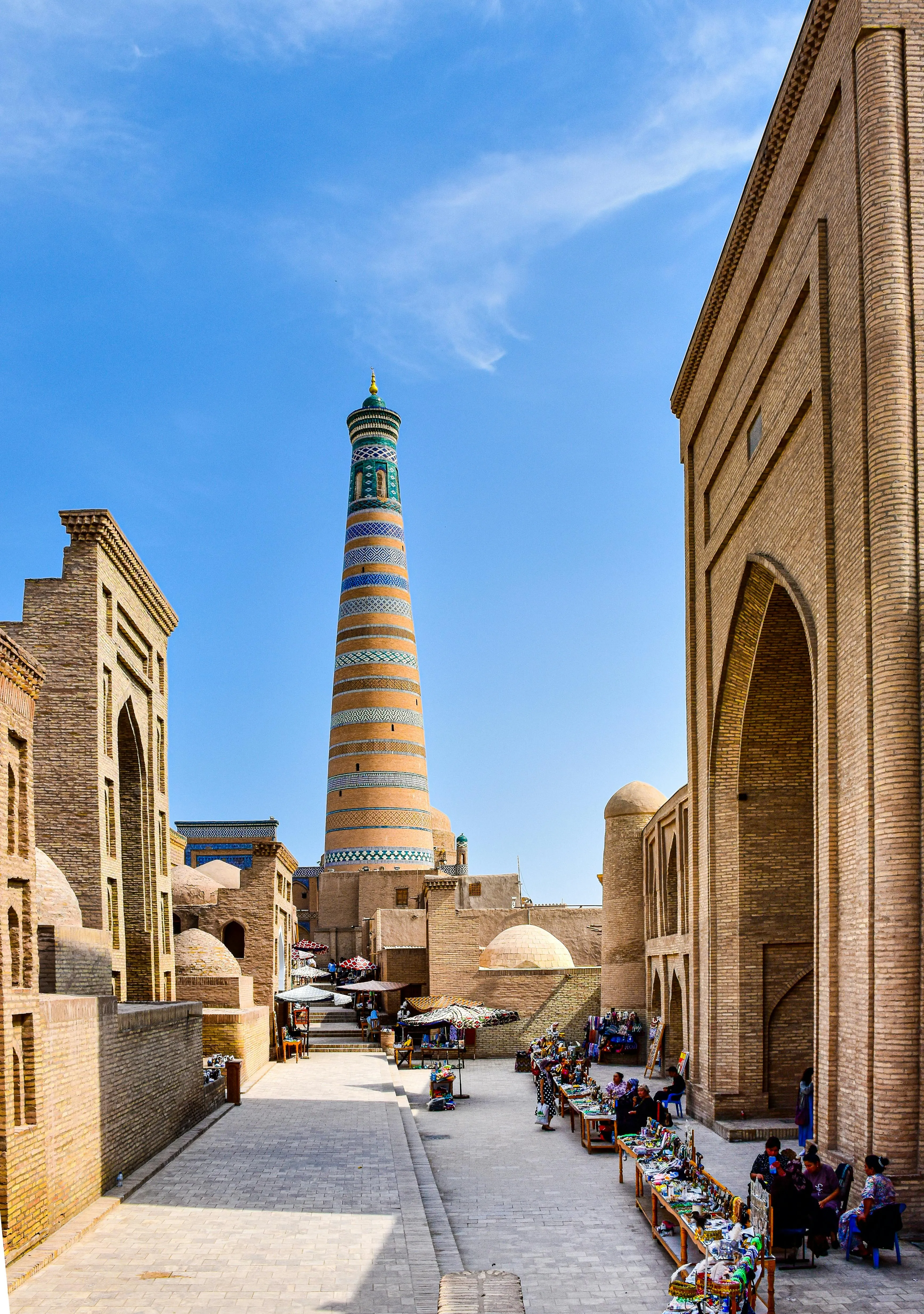 The historic Kalta Minor Minaret in Khiva, Uzbekistan, surrounded by ancient architecture.
