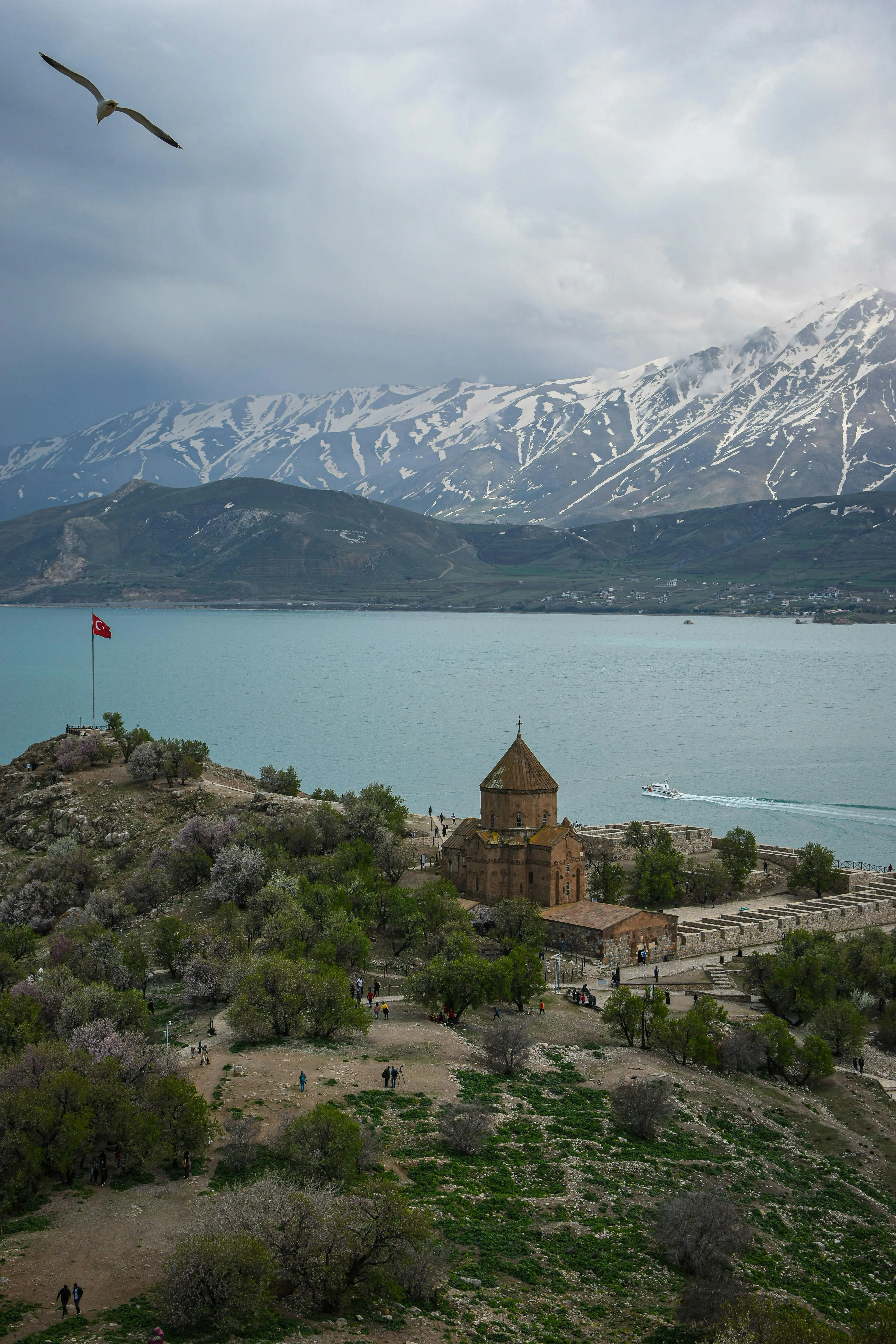 Aerial view of Akdamar Island’s church, surrounded by Lake Van and snow-capped mountains.