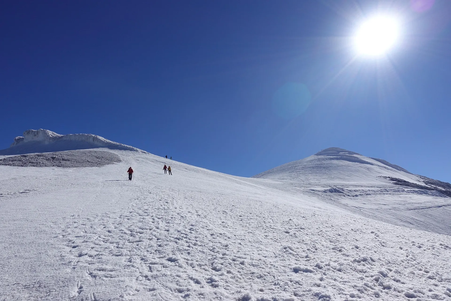 Snow-covered slopes of Mount Ararat under a bright sun, with climbers ascending.