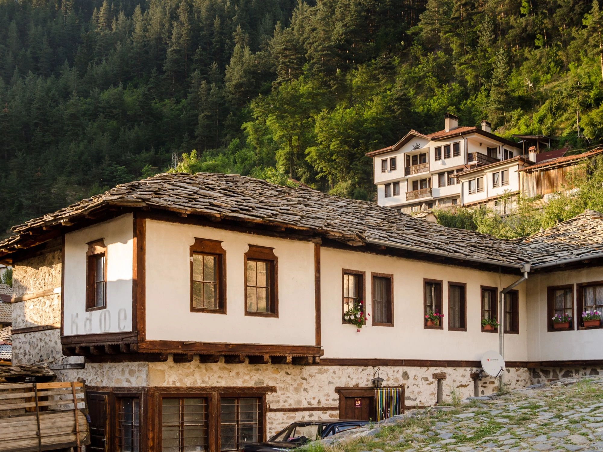 Traditional white houses with stone roofs in Shiroka Laka village, nestled in the Rhodope Mountains, Bulgaria.