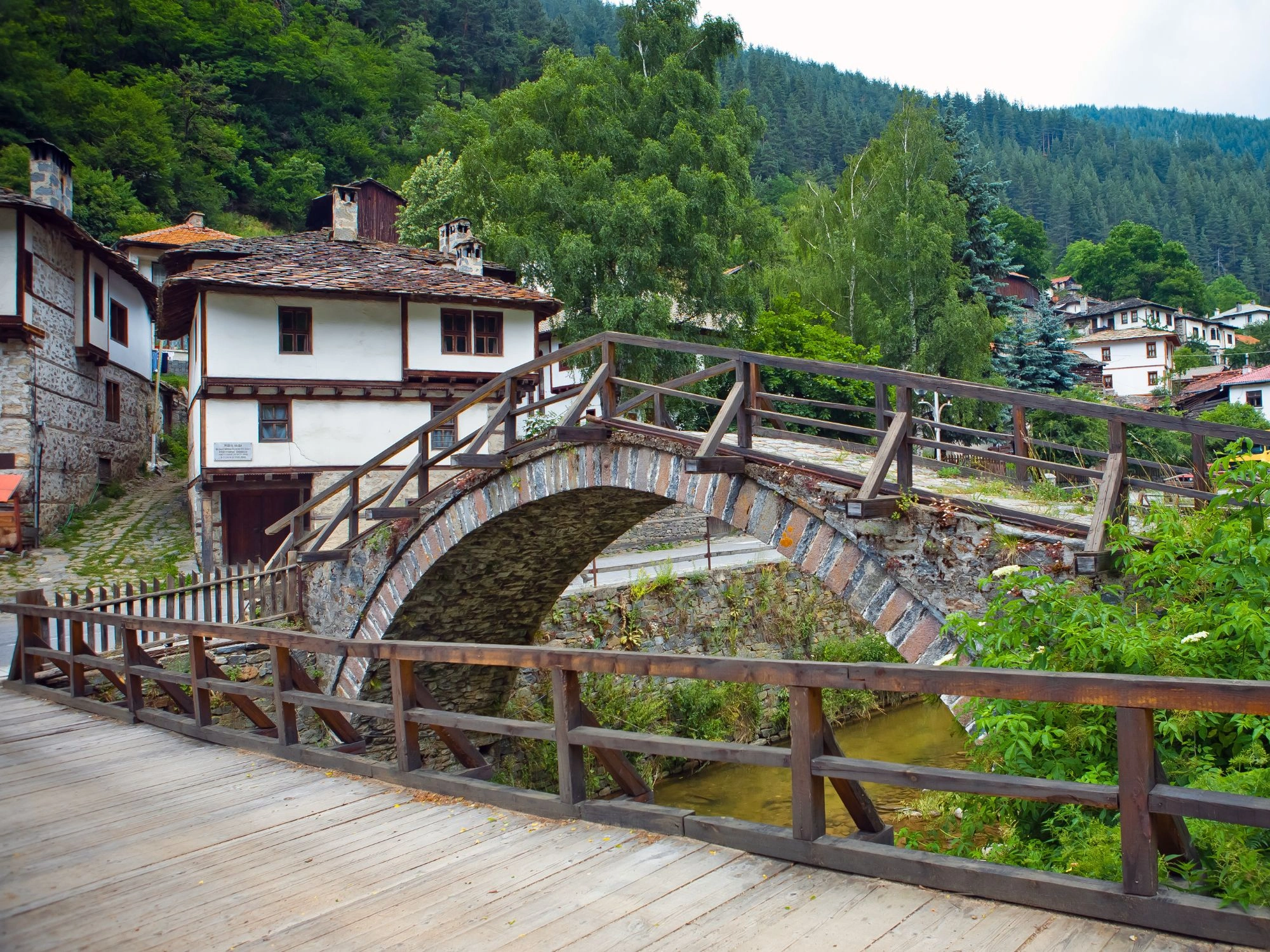 Historic stone bridge over a small stream in Shiroka Laka village, Rhodope Mountains, Bulgaria.