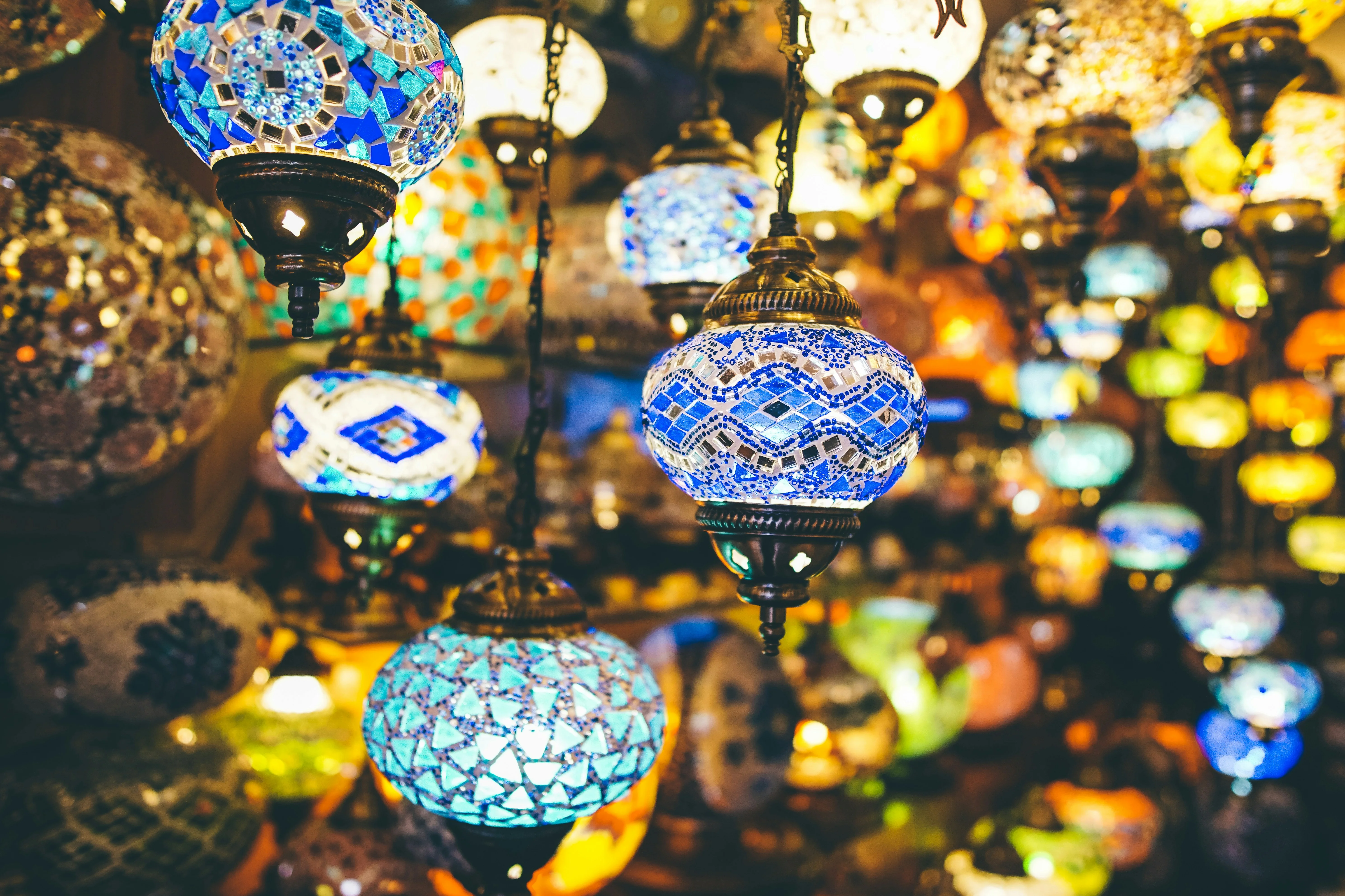 Hanging mosaic lamps in vibrant colors, glowing with stained-glass patterns.